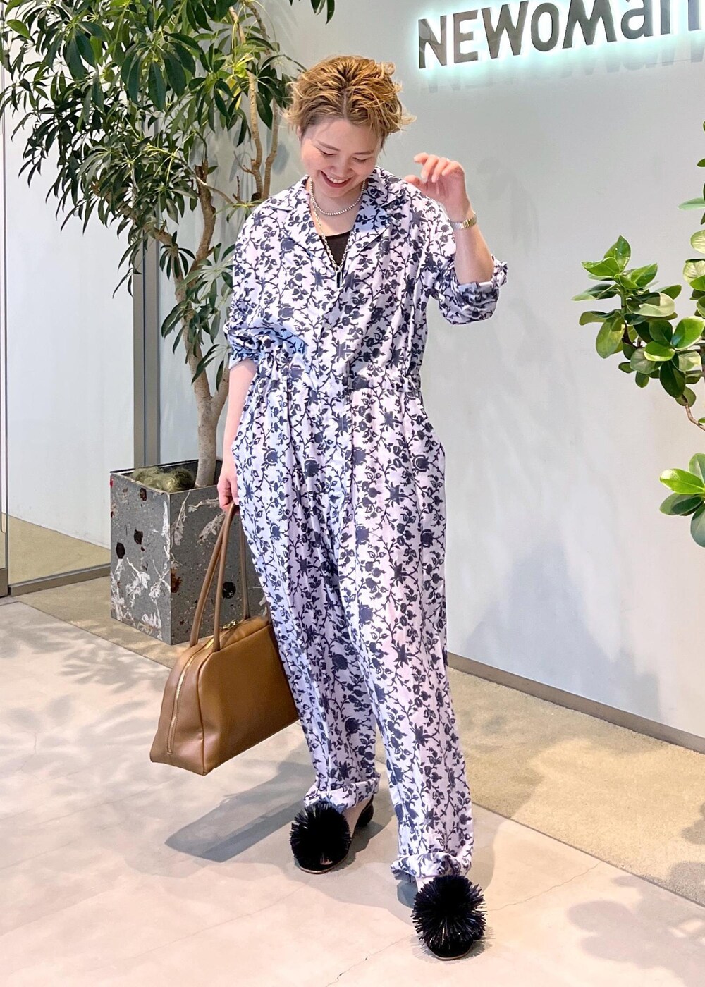 ブラウン系のボストンバッグ、ブラック系のサンダルを着用したレディースの夏コーディネートの2枚目の写真