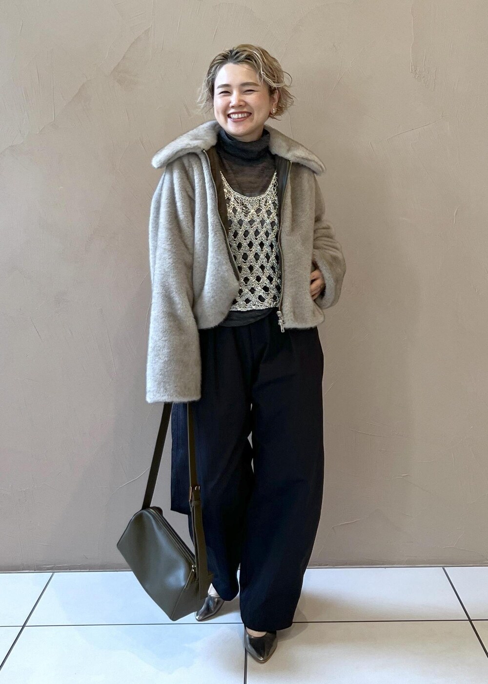 シルバー系のベスト、グレー系のブルゾン、グレー系のニット/セーターを着用したレディースの秋コーディネートの3枚目の写真