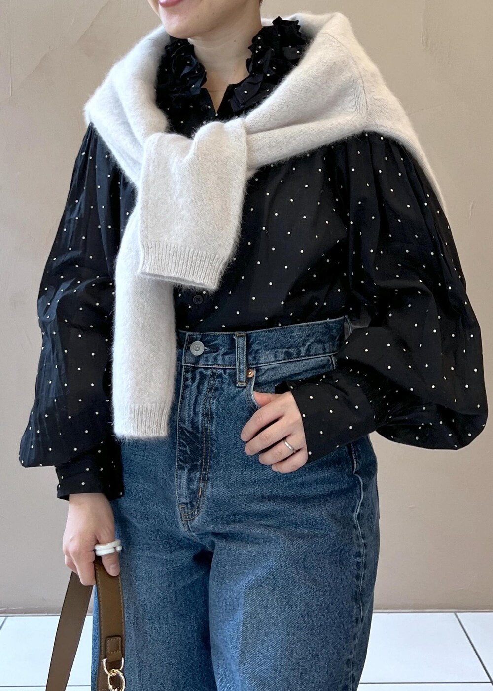 グレー系のニット/セーター、ブルー系のデニムパンツ、ブラウン系のショルダーバッグを着用したレディースの秋コーディネートの7枚目の写真
