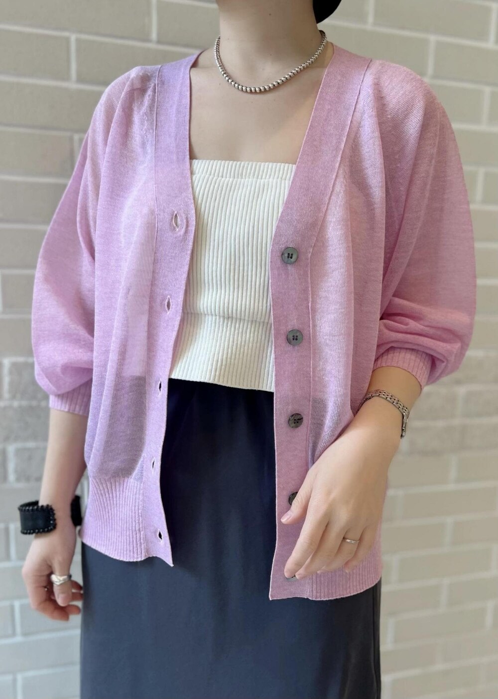 グレー系のスカート、ピンク系のカーディガン/ボレロ、ホワイト系のチューブトップを着用したレディースの春コーディネートの5枚目の写真