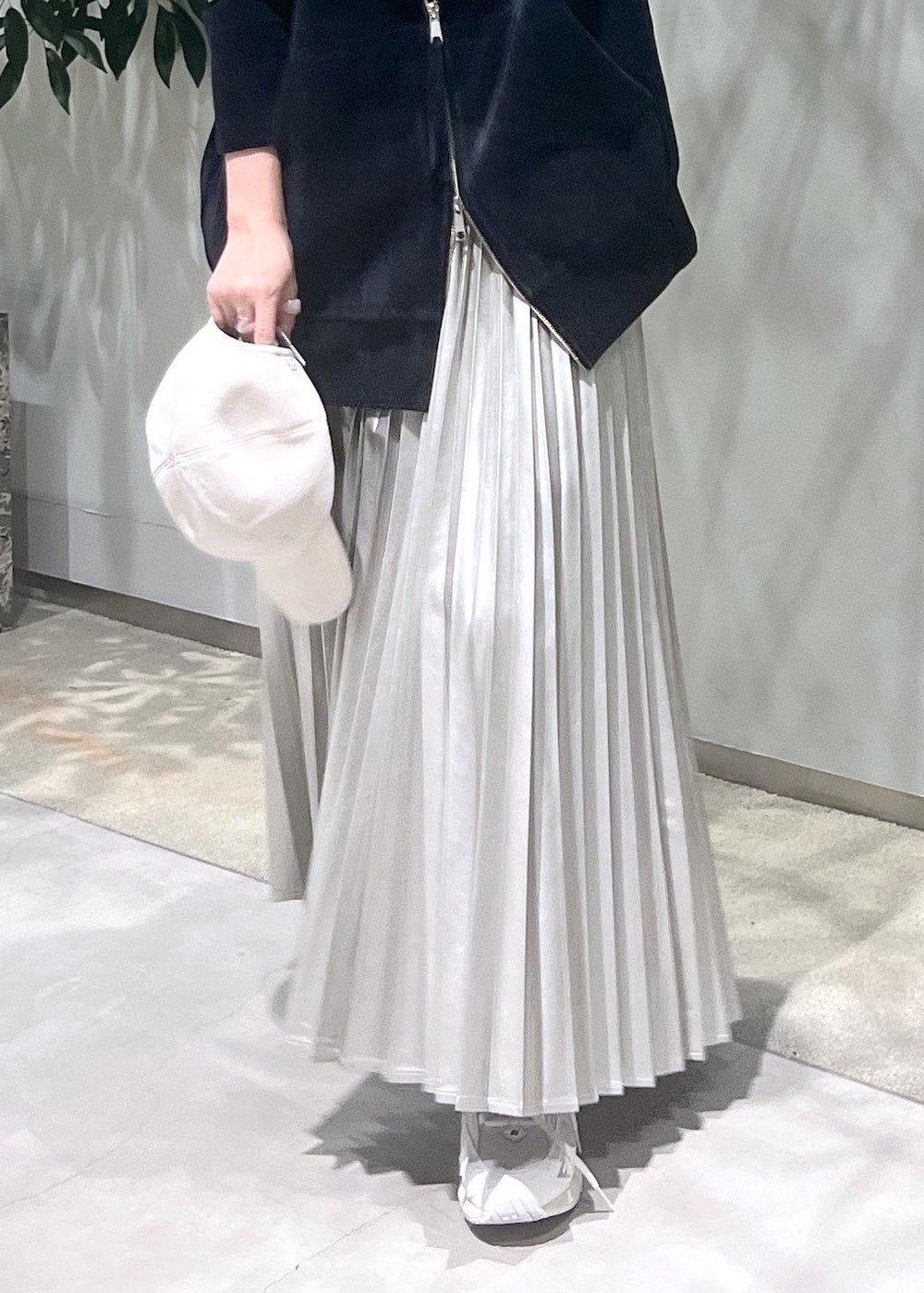 ベージュ系のスカート、ブラック系のタンクトップ、ブラック系のパーカーを着用したレディースの秋コーディネートの10枚目の写真