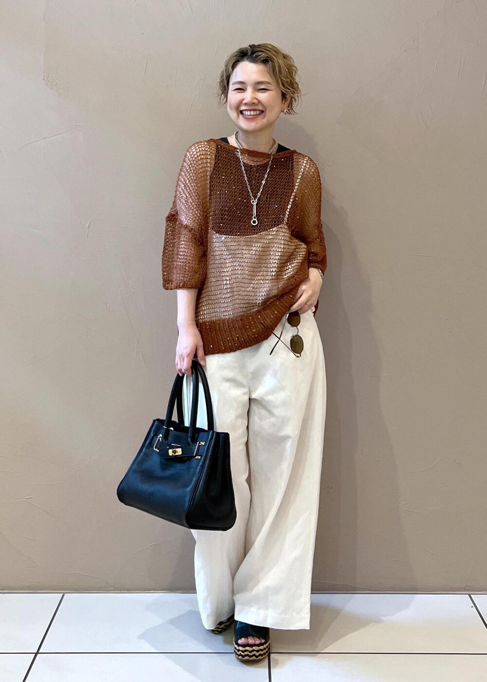 ホワイト系のサロペット/オーバーオール、グレー系のタンクトップ、ブラック系のショルダーバッグを着用したレディースの夏コーディネートの2枚目の写真