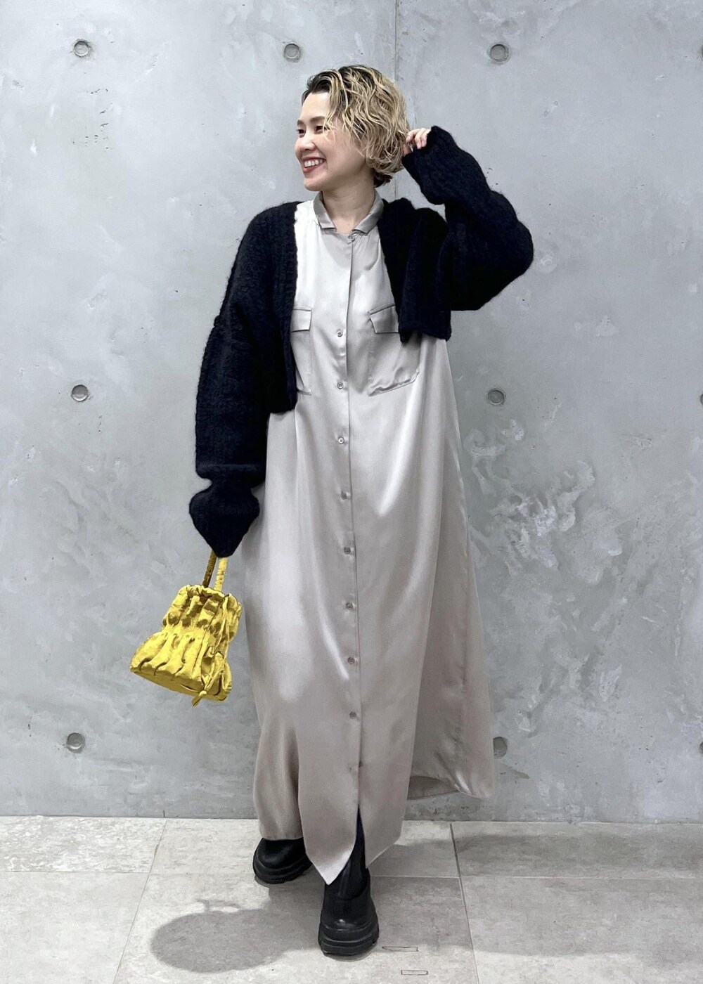 イエロー系のショルダーバッグ、グレー系のシャツワンピース、ブラック系のカーディガン/ボレロを着用したレディースの秋コーディネートの2枚目の写真