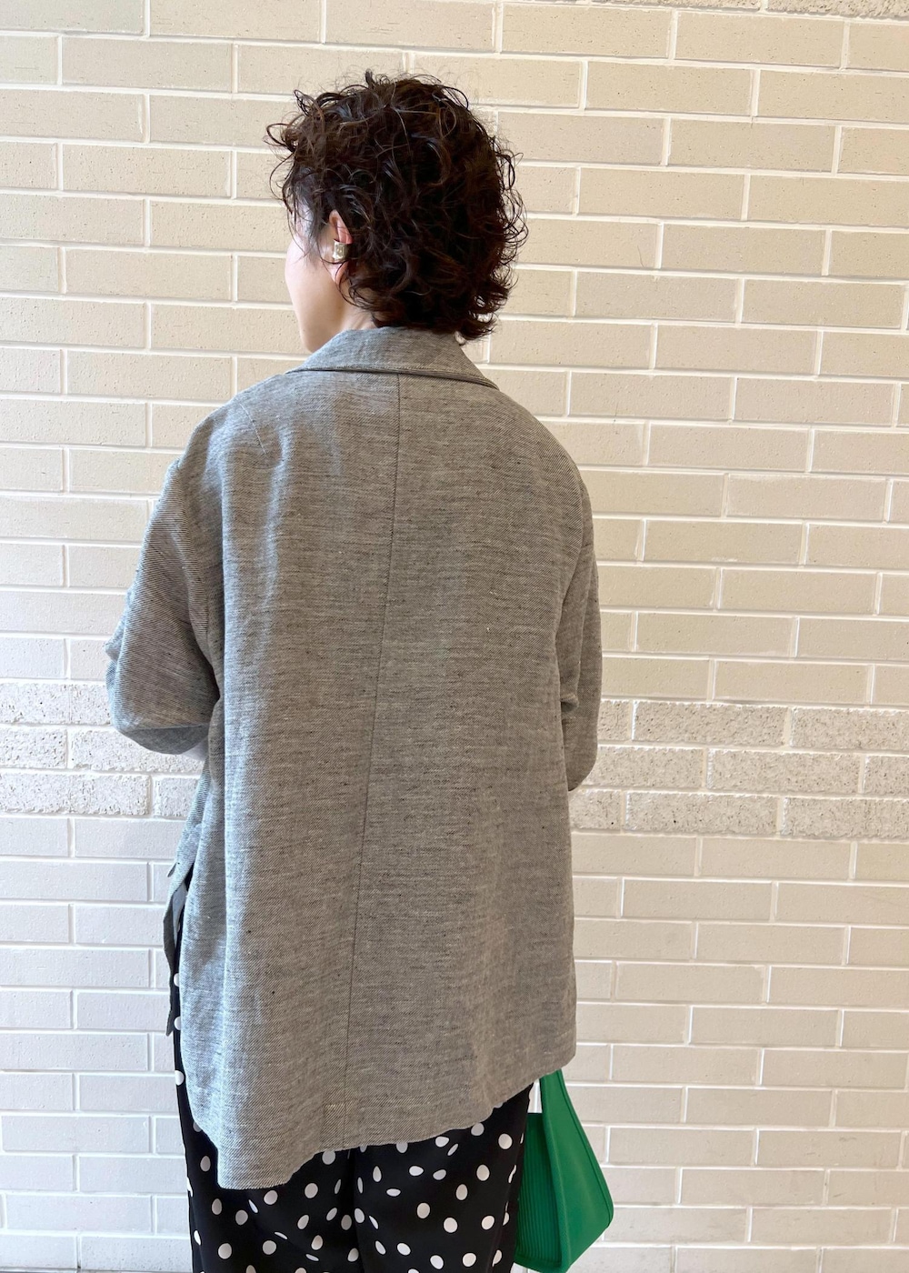 ホワイト系のタンクトップ、グリーン系のハンドバッグ、ブラック系のサンダルを着用したレディースの夏コーディネートの6枚目の写真