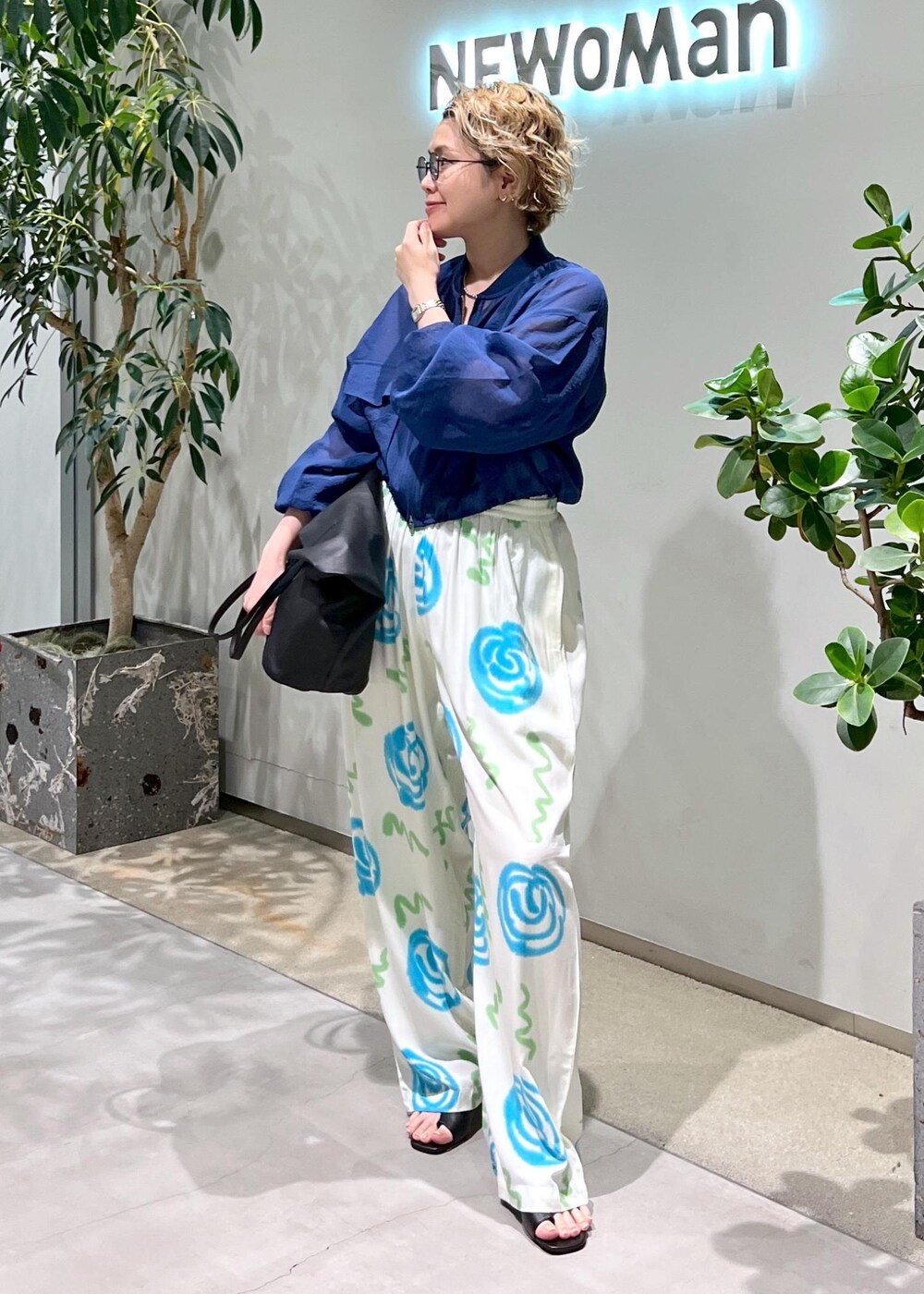 ブラック系のサンダル、ブルー系のブルゾン、ブラック系のサングラスを着用したレディースの春コーディネートの2枚目の写真