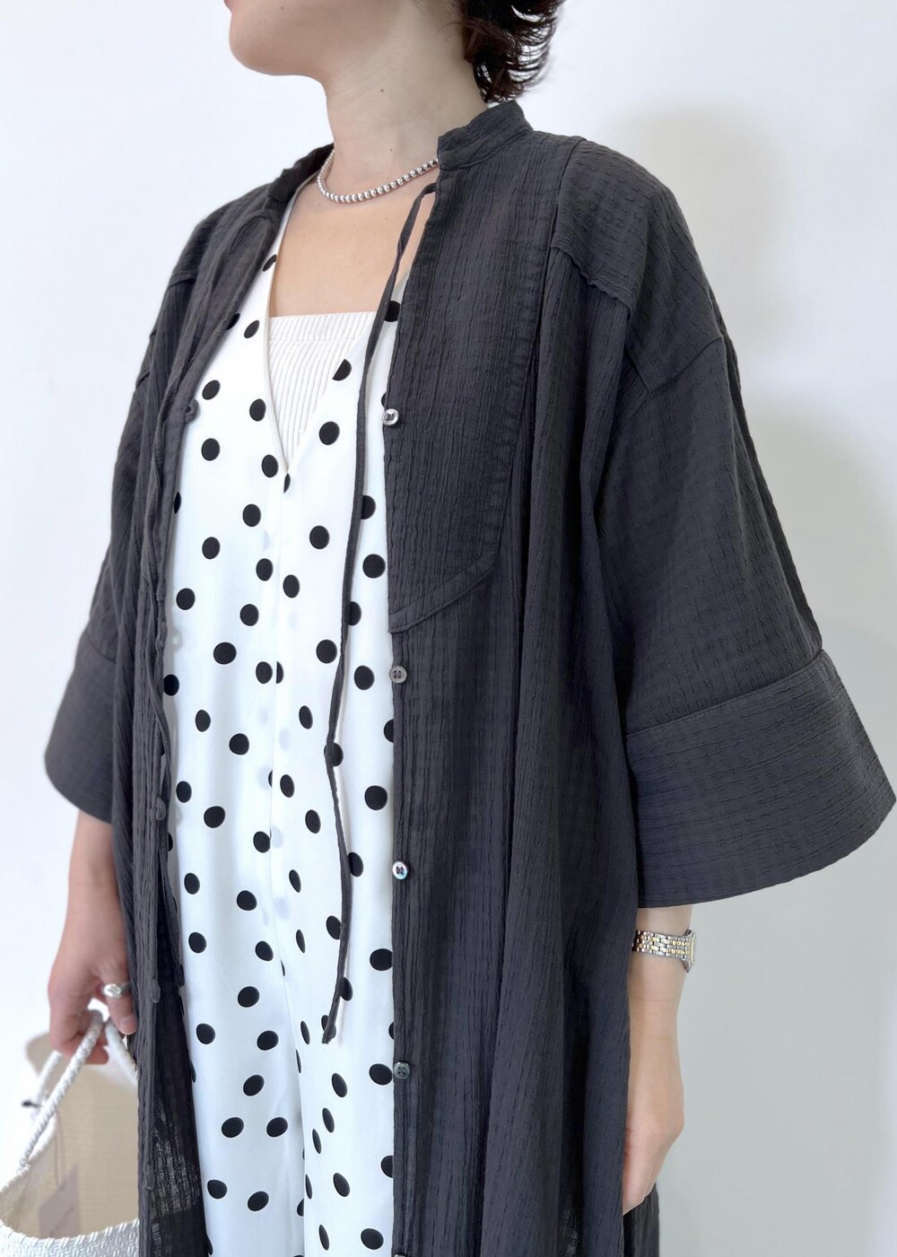 ホワイト系のつなぎ/オールインワン、ホワイト系のかごバッグ、ブラック系のシャツ/ブラウスを着用したレディースの夏コーディネートの5枚目の写真