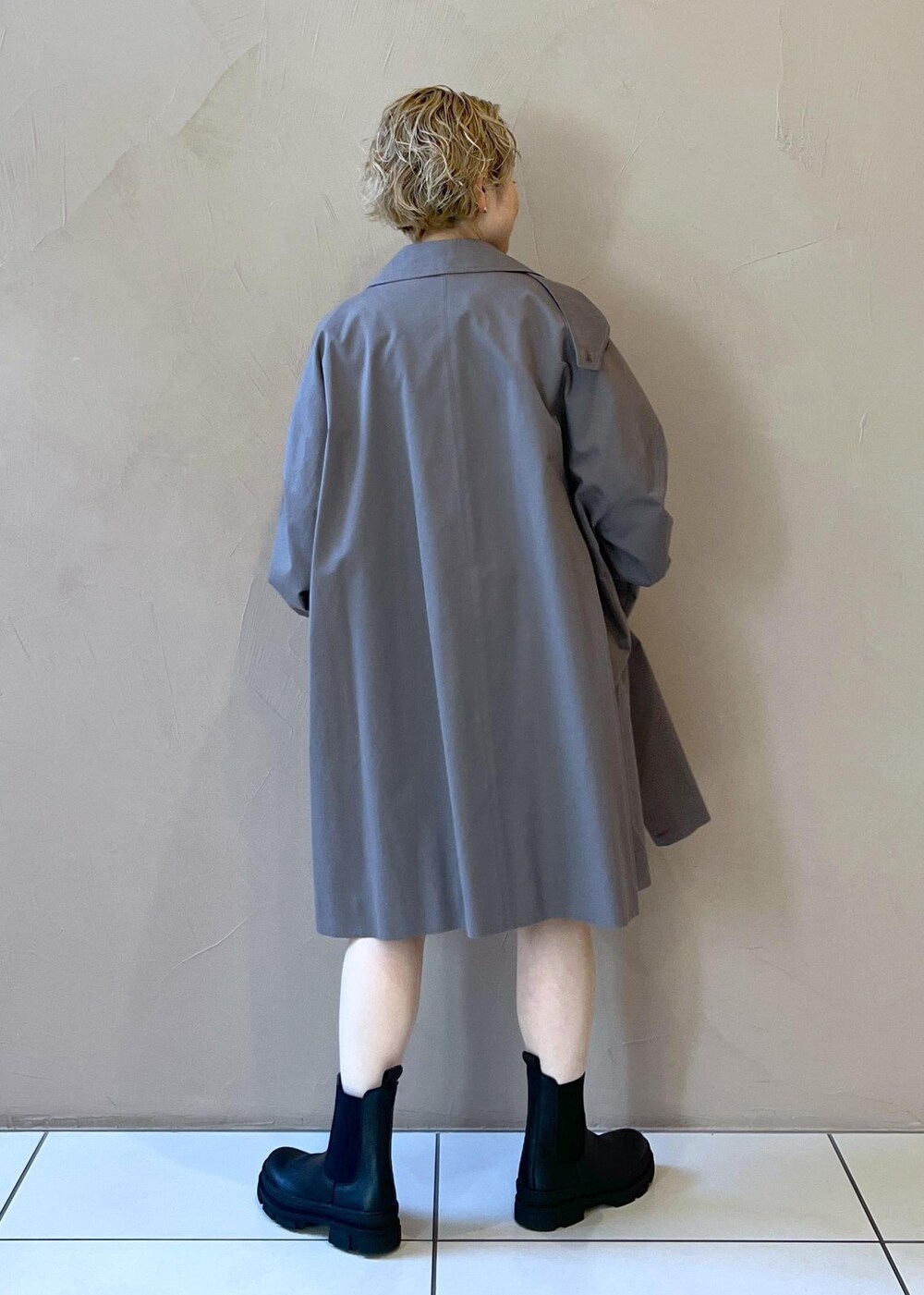 ブラック系のブーツ、ホワイト系のニット/セーター、グレー系のステンカラーコートを着用したレディースの冬コーディネートの6枚目の写真