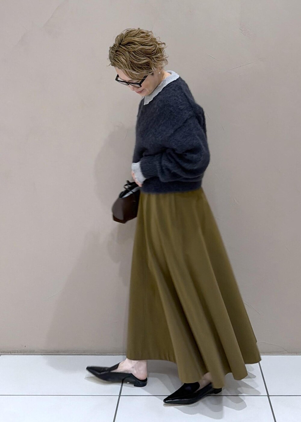 ブラウン系のスカート、ブラック系のローファー、グレー系のニット/セーターを着用したレディースの冬コーディネートの4枚目の写真