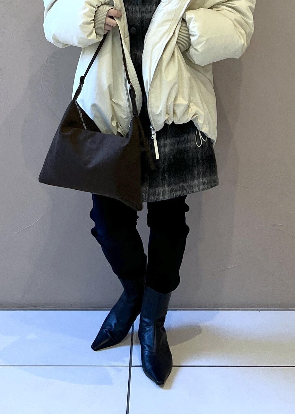 ホワイト系のダウンジャケット/コート、グレー系のジャンパースカート、ブラウン系のショルダーバッグを着用したレディースの秋コーディネートの10枚目の写真