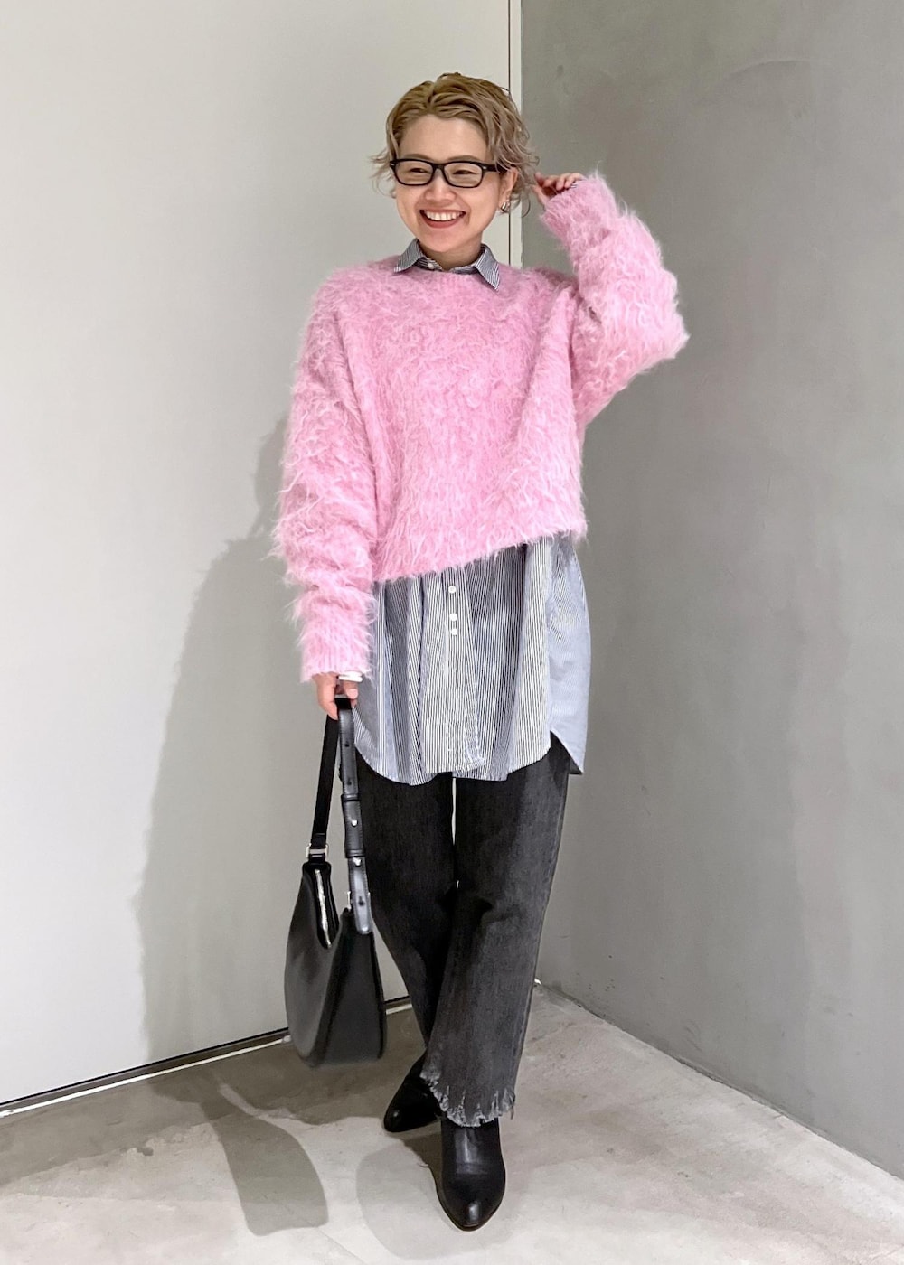 ブラック系のブーツ、ピンク系のニット/セーター、ブラック系のデニムパンツを着用したレディースの秋コーディネートの3枚目の写真