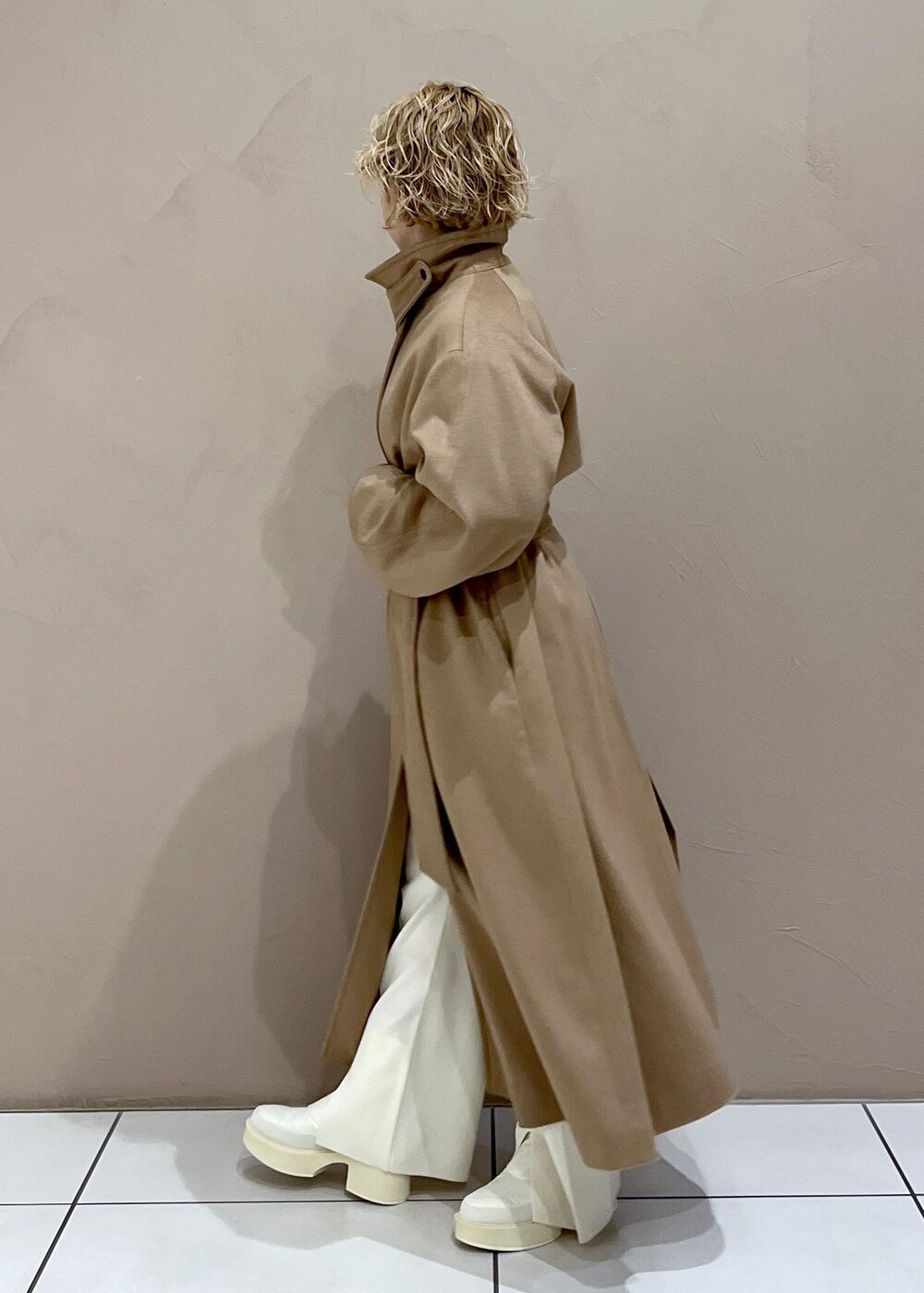 ブラウン系のハンドバッグ、ホワイト系のTシャツ/カットソー、イエロー系のステンカラーコートを着用したレディースの冬コーディネートの4枚目の写真