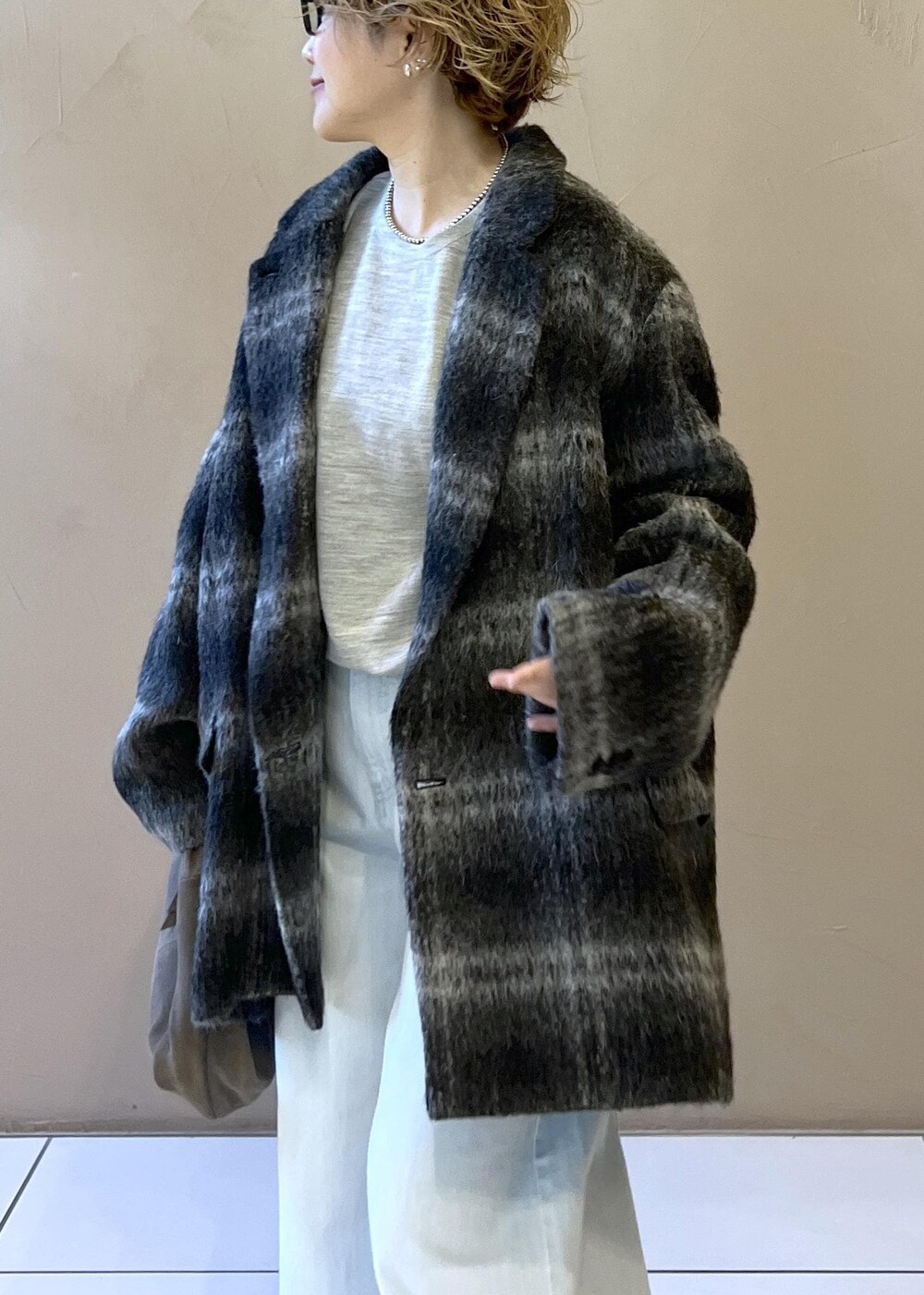 ブルー系のデニムパンツ、グレー系のその他アウター、グレー系のハンドバッグを着用したレディースの秋コーディネートの8枚目の写真