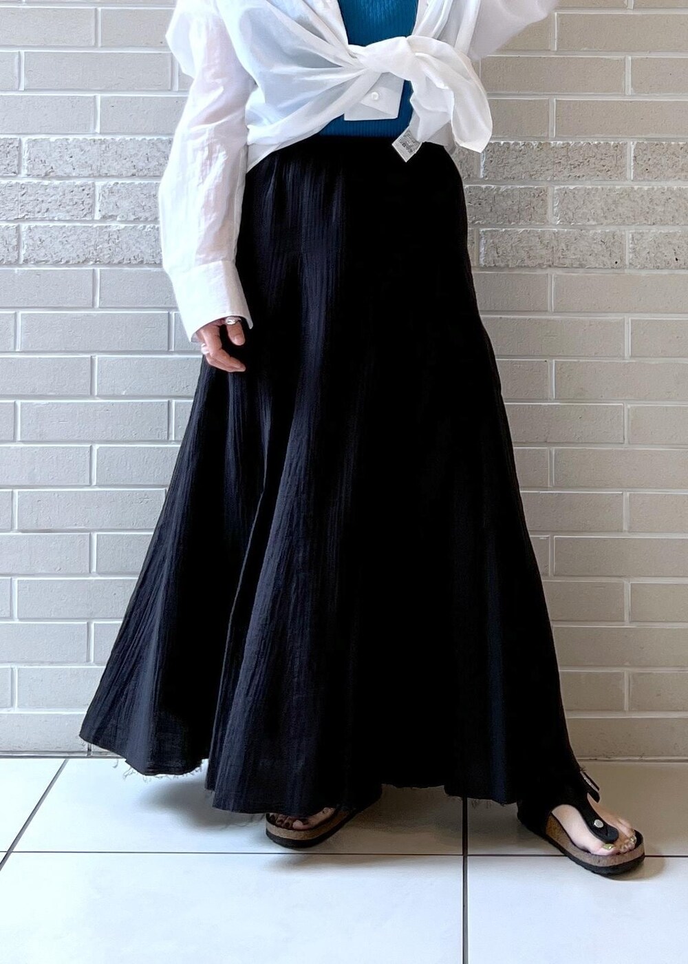 ブラック系のスカート、ホワイト系のシャツ/ブラウス、ブルー系のタンクトップを着用したレディースの夏コーディネートの8枚目の写真