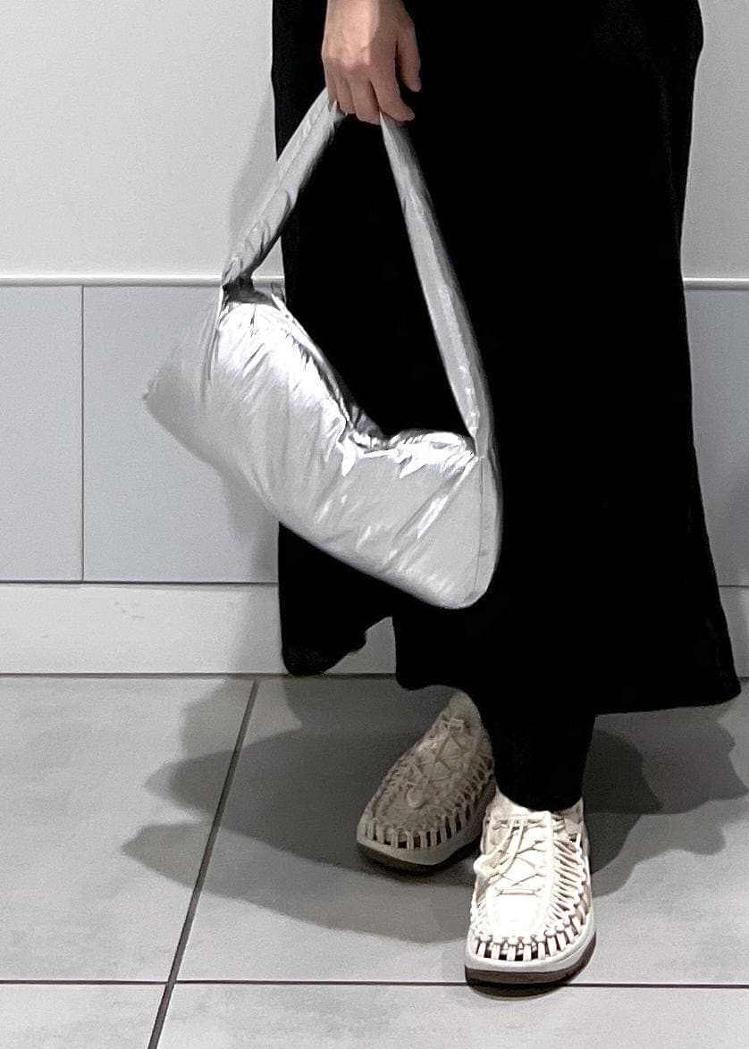 シルバー系のハンドバッグ、ホワイト系のサンダル、ブラック系のスカートを着用したレディースの春コーディネートの10枚目の写真