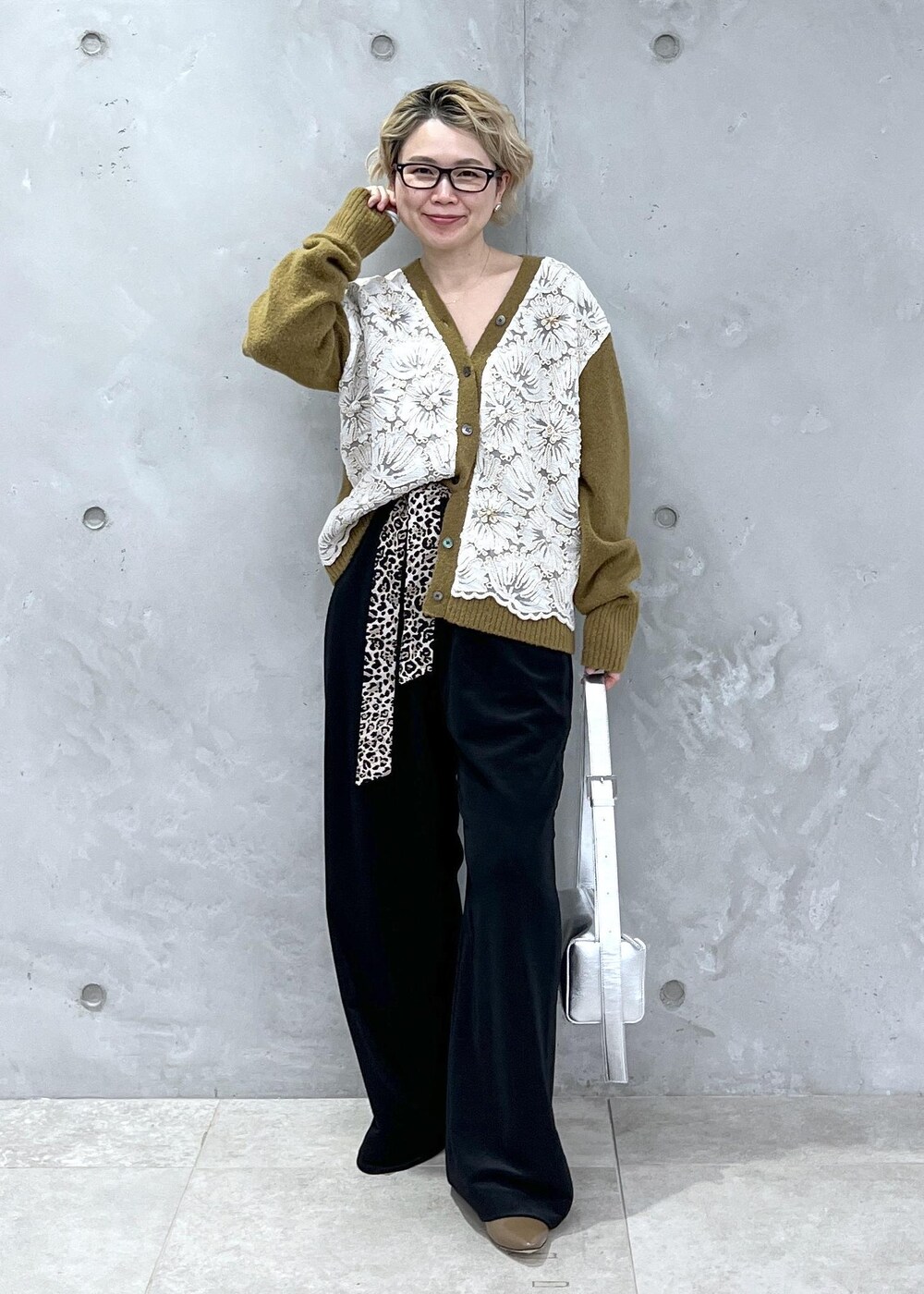 イエロー系のカーディガン/ボレロ、シルバー系のショルダーバッグ、ブラック系のその他パンツを着用したレディースの冬コーディネートの3枚目の写真