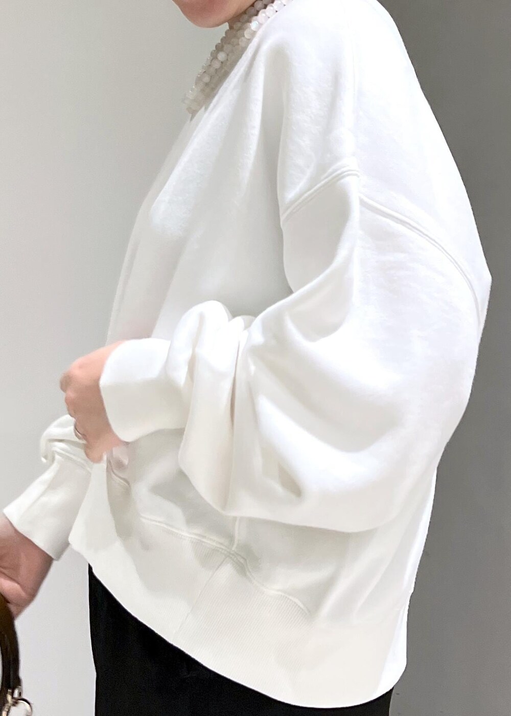 ホワイト系のスウェット、ブラック系のカーゴパンツ、ブラウン系のショルダーバッグを着用したレディースの秋コーディネートの8枚目の写真