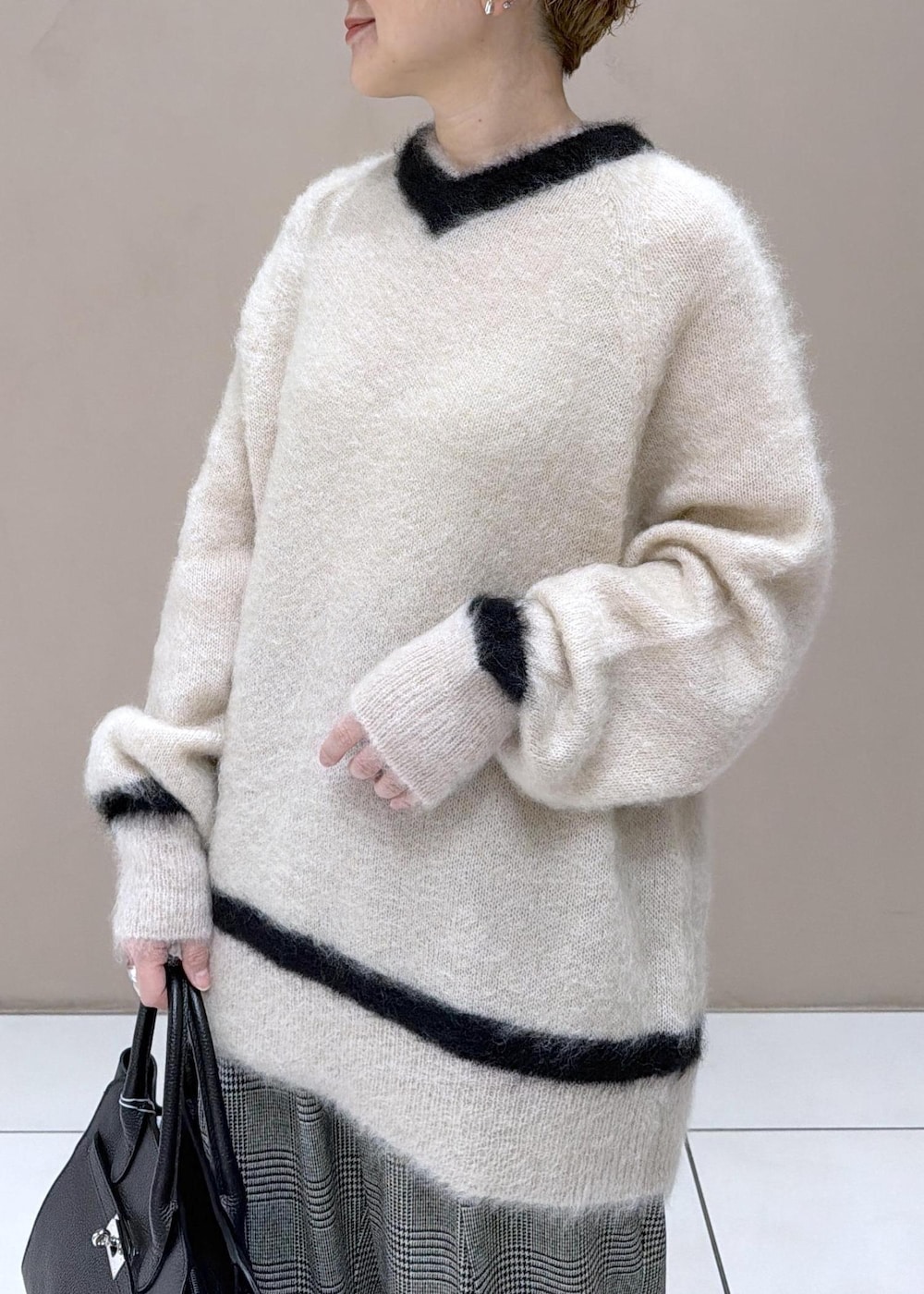 グレー系のスラックス、ブラック系のブーツを着用したレディースの冬コーディネートの6枚目の写真