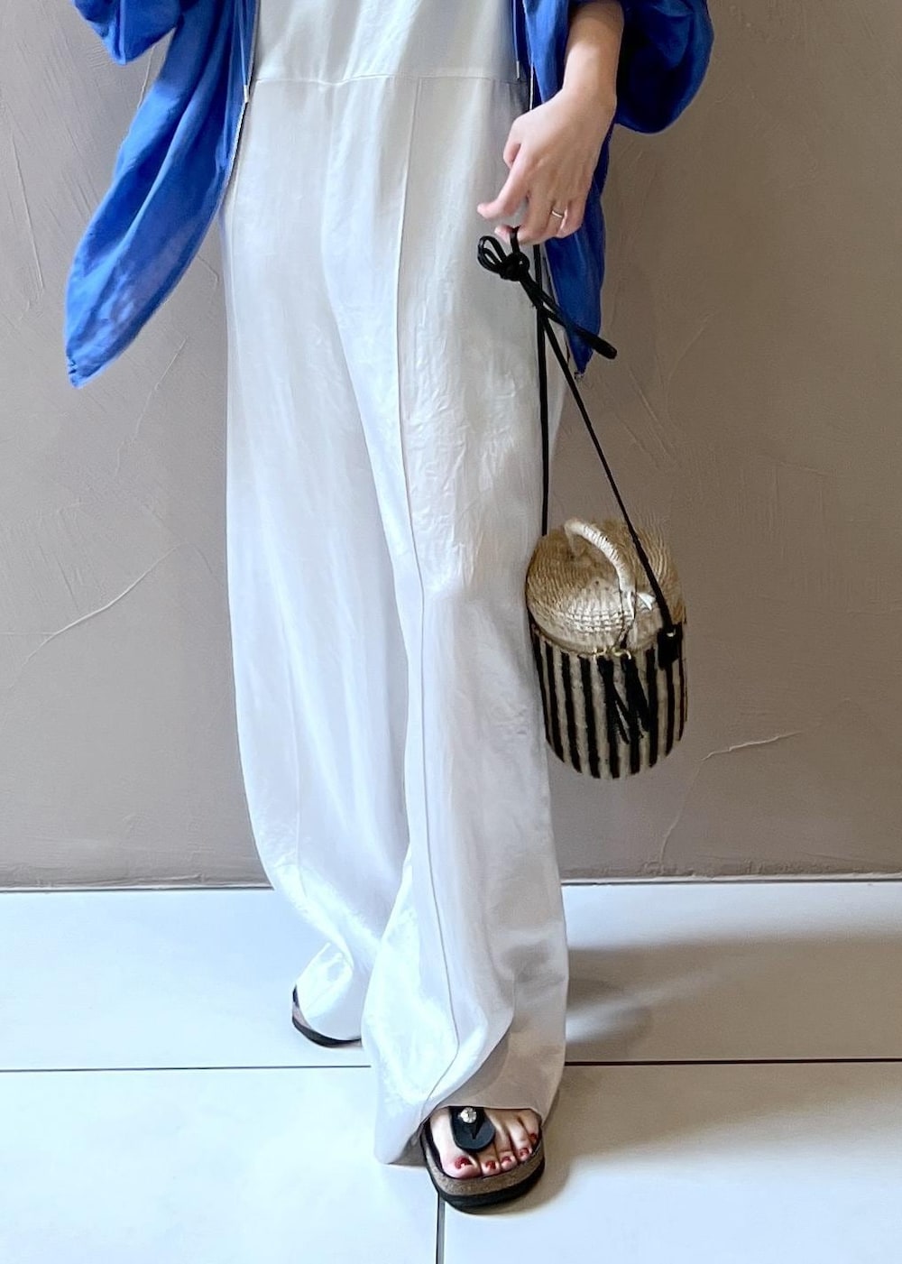 ホワイト系のショルダーバッグ、ブルー系のブルゾン、ホワイト系のつなぎ/オールインワンを着用したレディースの夏コーディネートの7枚目の写真