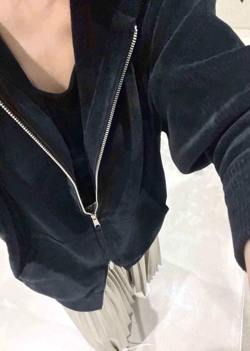 ベージュ系のスカート、ブラック系のタンクトップ、ブラック系のパーカーを着用したレディースの秋コーディネートの8枚目の写真