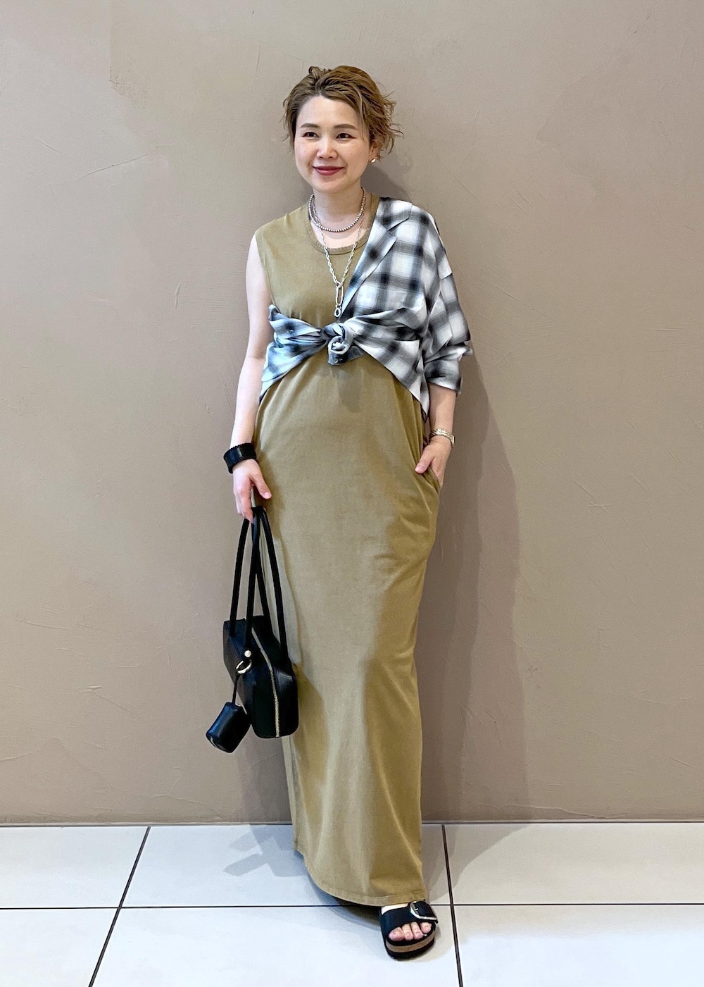 ブラック系のショルダーバッグ、ブラック系のシャツ/ブラウス、ブラウン系のワンピースを着用したレディースの夏コーディネートの3枚目の写真