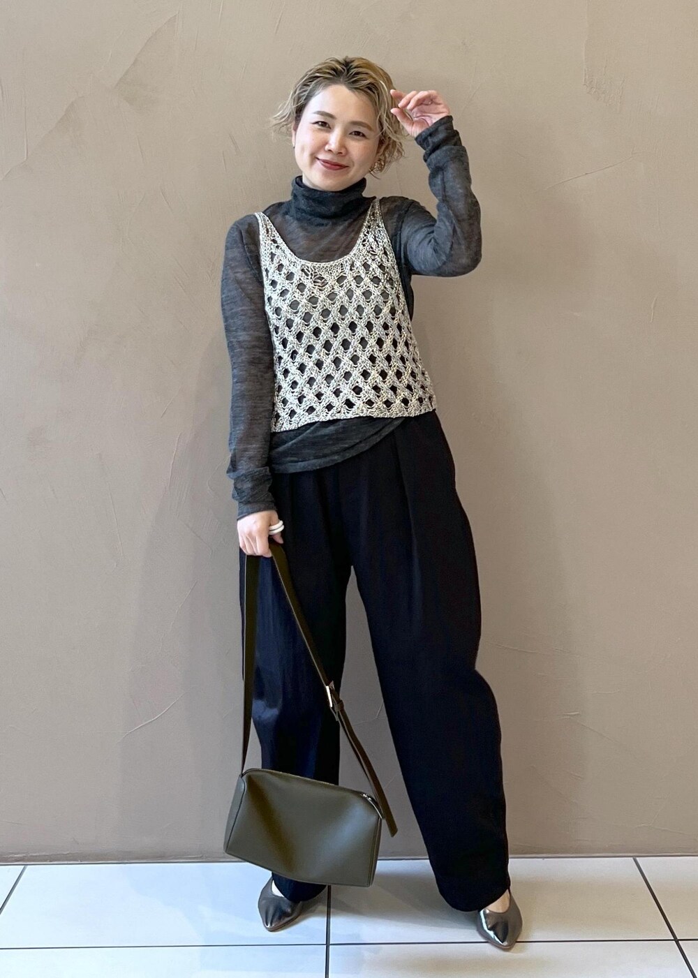 シルバー系のベスト、グレー系のニット/セーター、ブラック系のその他パンツを着用したレディースの秋コーディネートの4枚目の写真