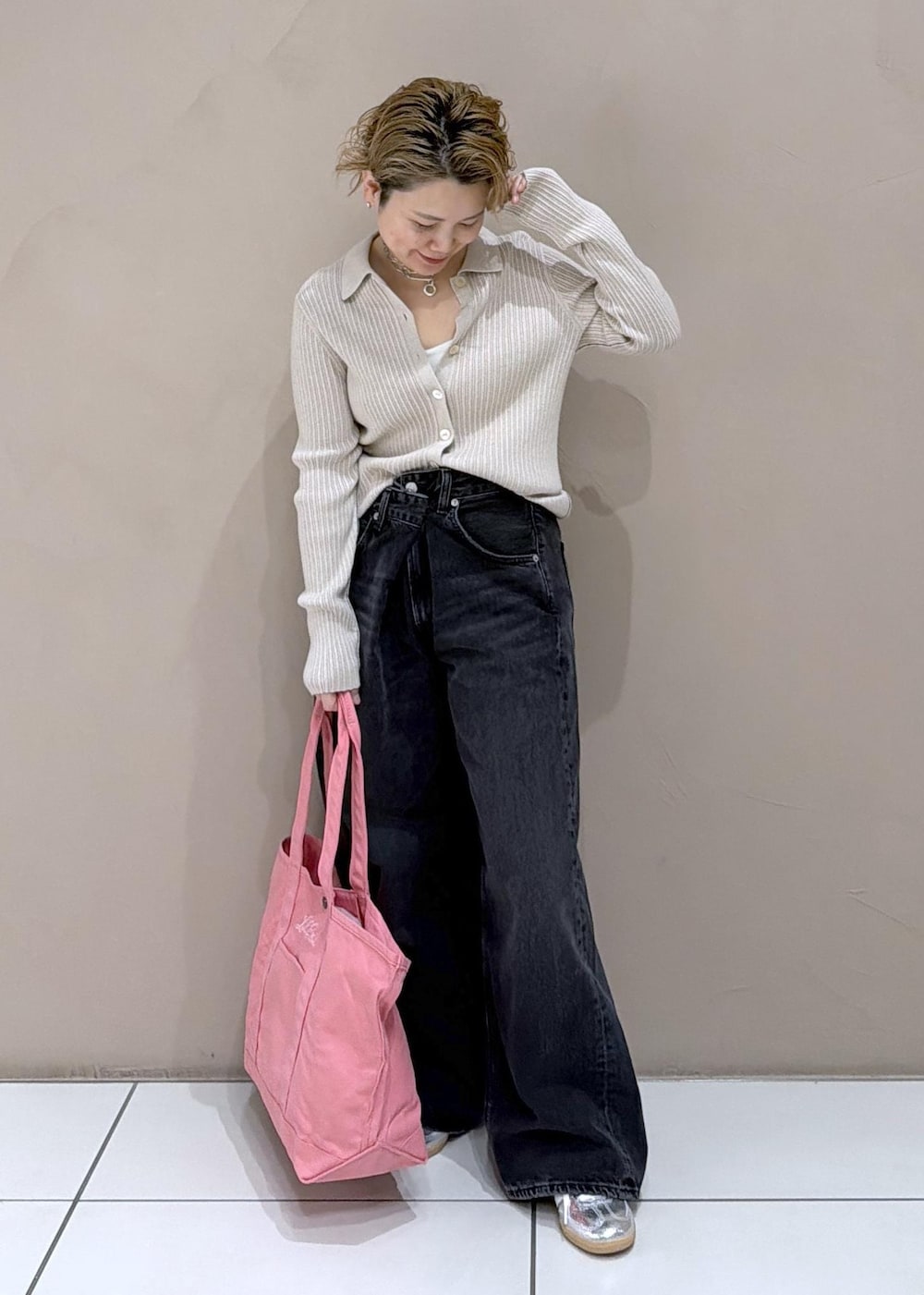 ベージュ系のカーディガン/ボレロ、ピンク系のトートバッグ、ブラック系のデニムパンツを着用したレディースの冬コーディネートの3枚目の写真