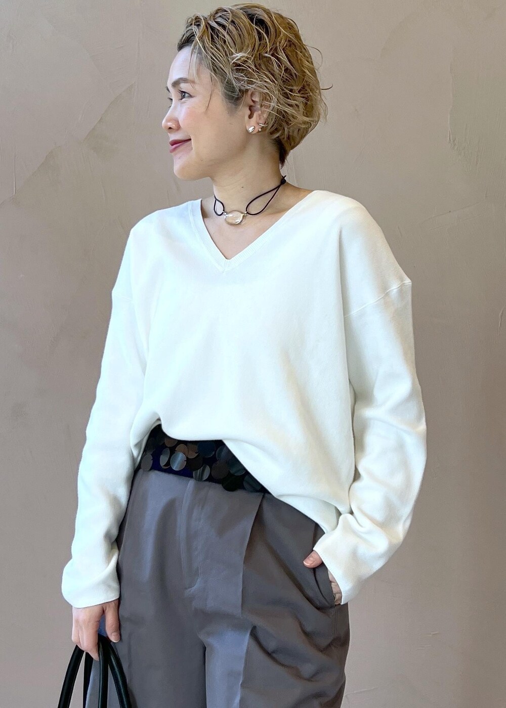 ブラック系のブーツ、ホワイト系のニット/セーター、グレー系のその他パンツを着用したレディースの冬コーディネートの5枚目の写真