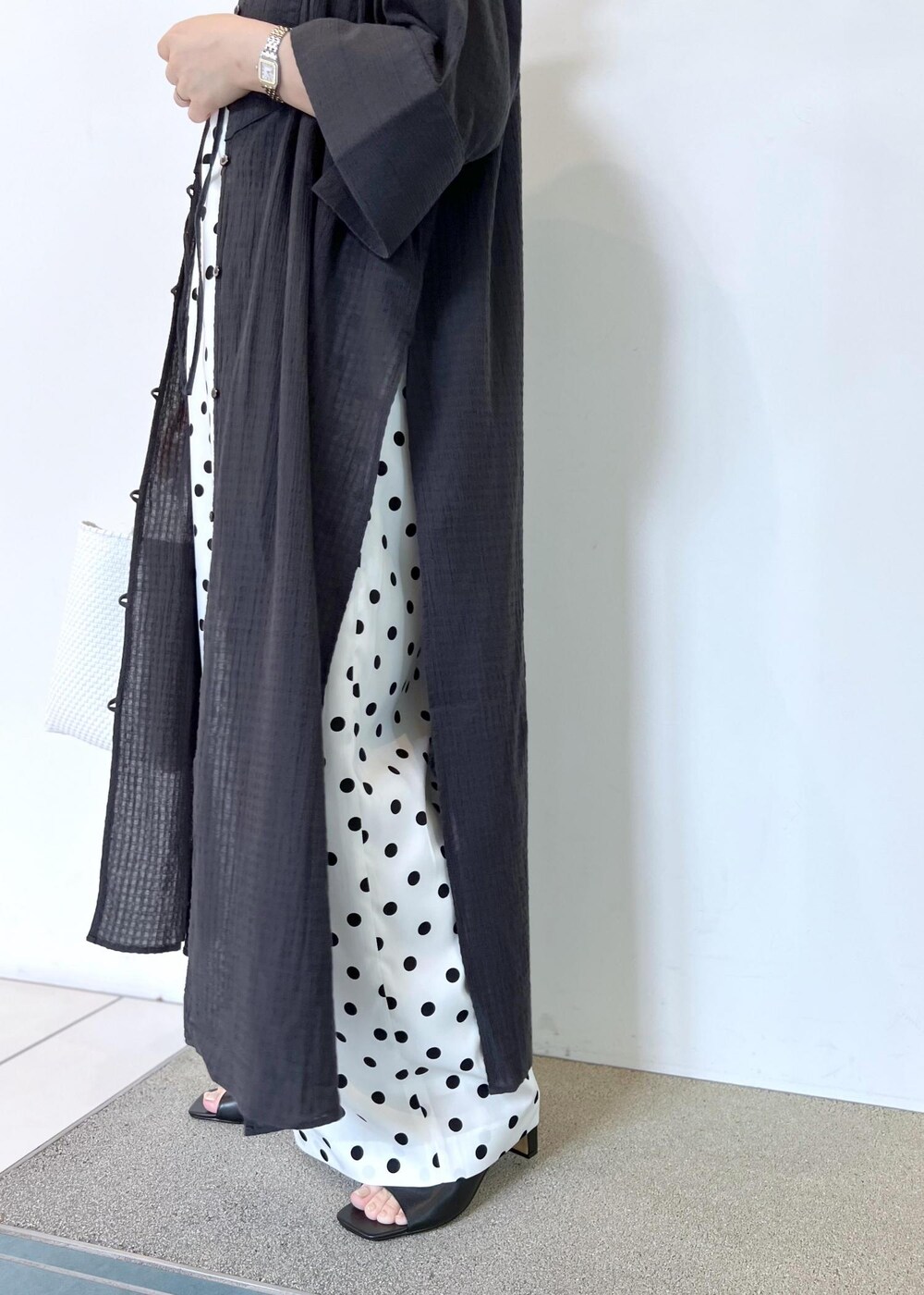 ホワイト系のつなぎ/オールインワン、ホワイト系のかごバッグ、ブラック系のシャツ/ブラウスを着用したレディースの夏コーディネートの6枚目の写真