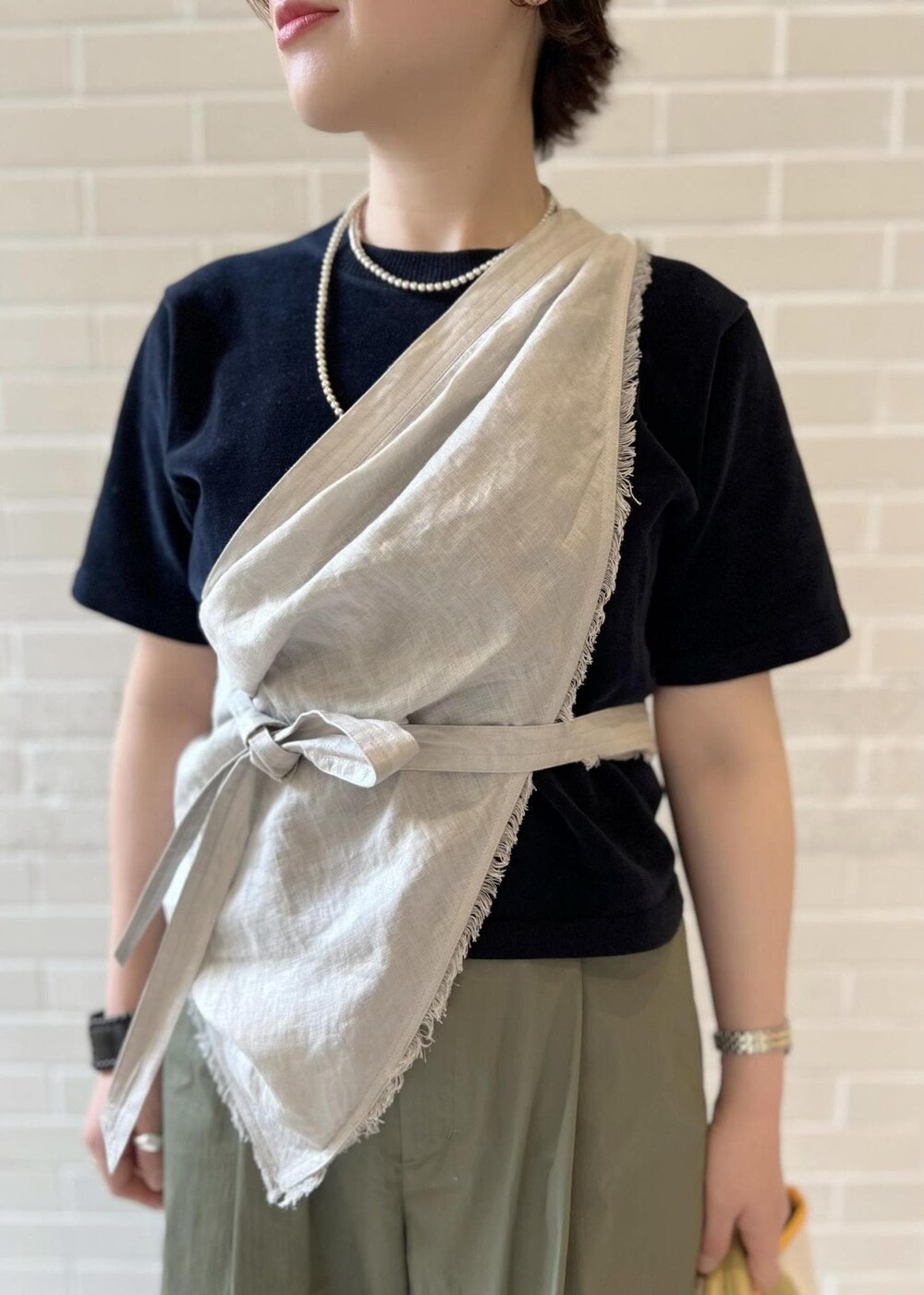 ホワイト系のトートバッグ、ブラック系のTシャツ/カットソー、グリーン系のその他パンツを着用したレディースの春コーディネートの5枚目の写真