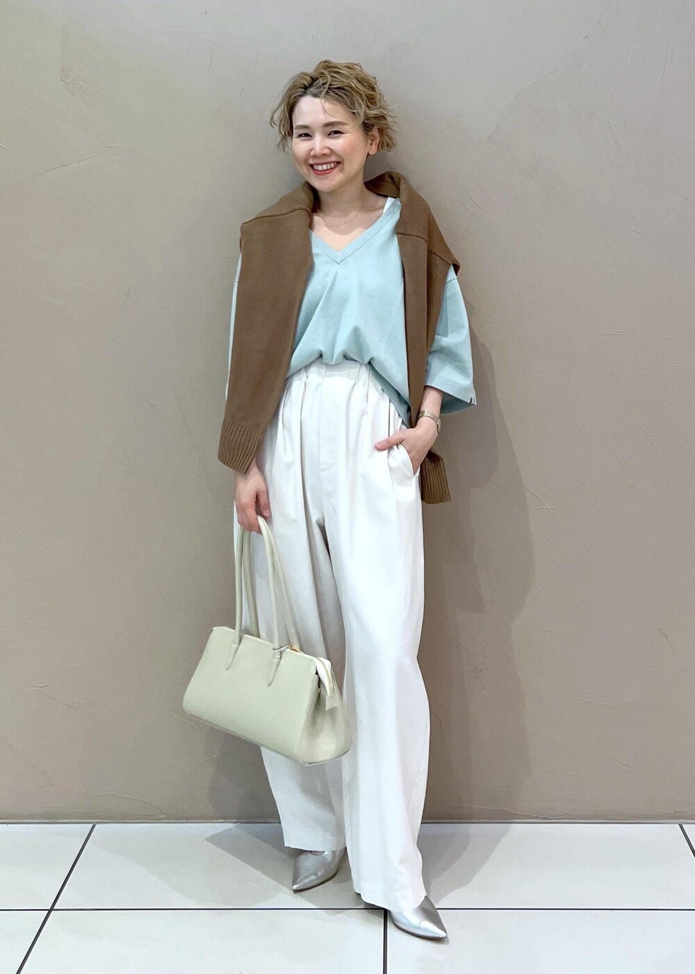 ホワイト系のボストンバッグ、イエロー系のカーディガン/ボレロ、ホワイト系のその他パンツを着用したレディースの春コーディネートの2枚目の写真