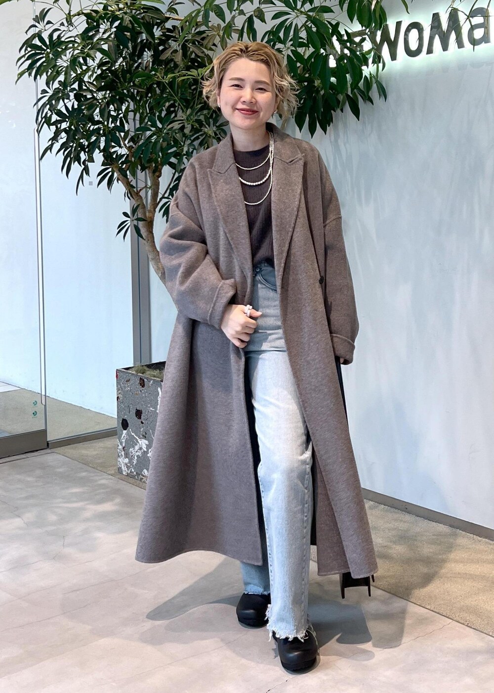 グレー系のニット/セーター、ブラック系のショルダーバッグ、ブラウン系のその他アウターを着用したレディースの秋コーディネートの3枚目の写真