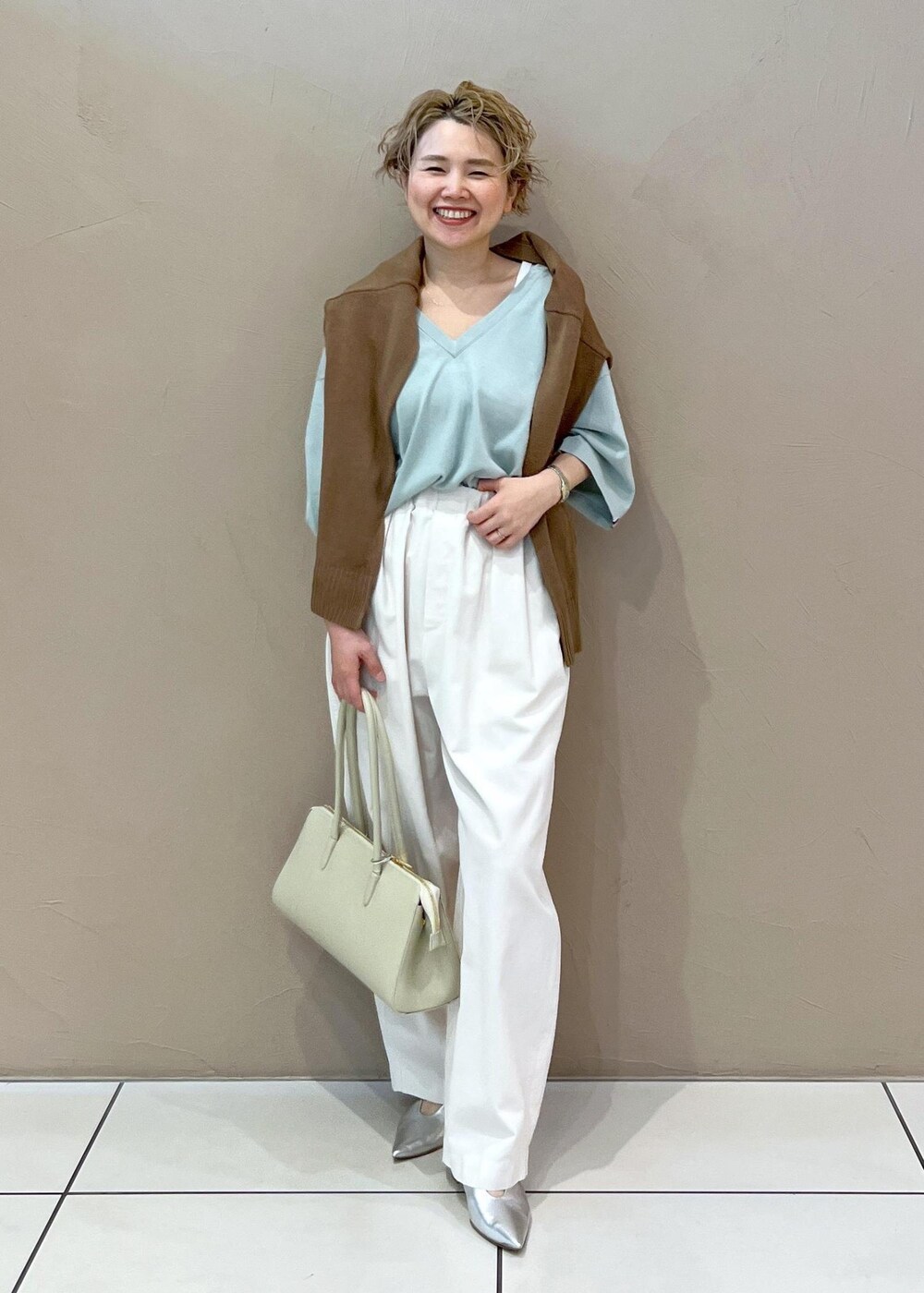 ホワイト系のボストンバッグ、イエロー系のカーディガン/ボレロ、ホワイト系のその他パンツを着用したレディースの春コーディネートの3枚目の写真