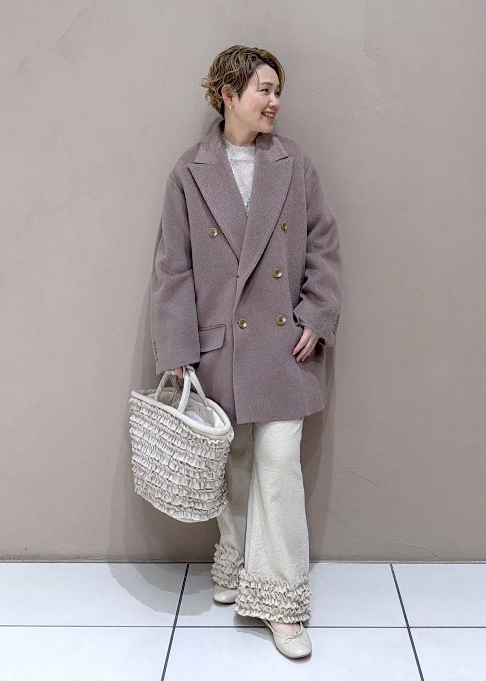 ベージュ系のパンプス、ブラウン系のチェスターコートを着用したレディースの冬コーディネートの4枚目の写真