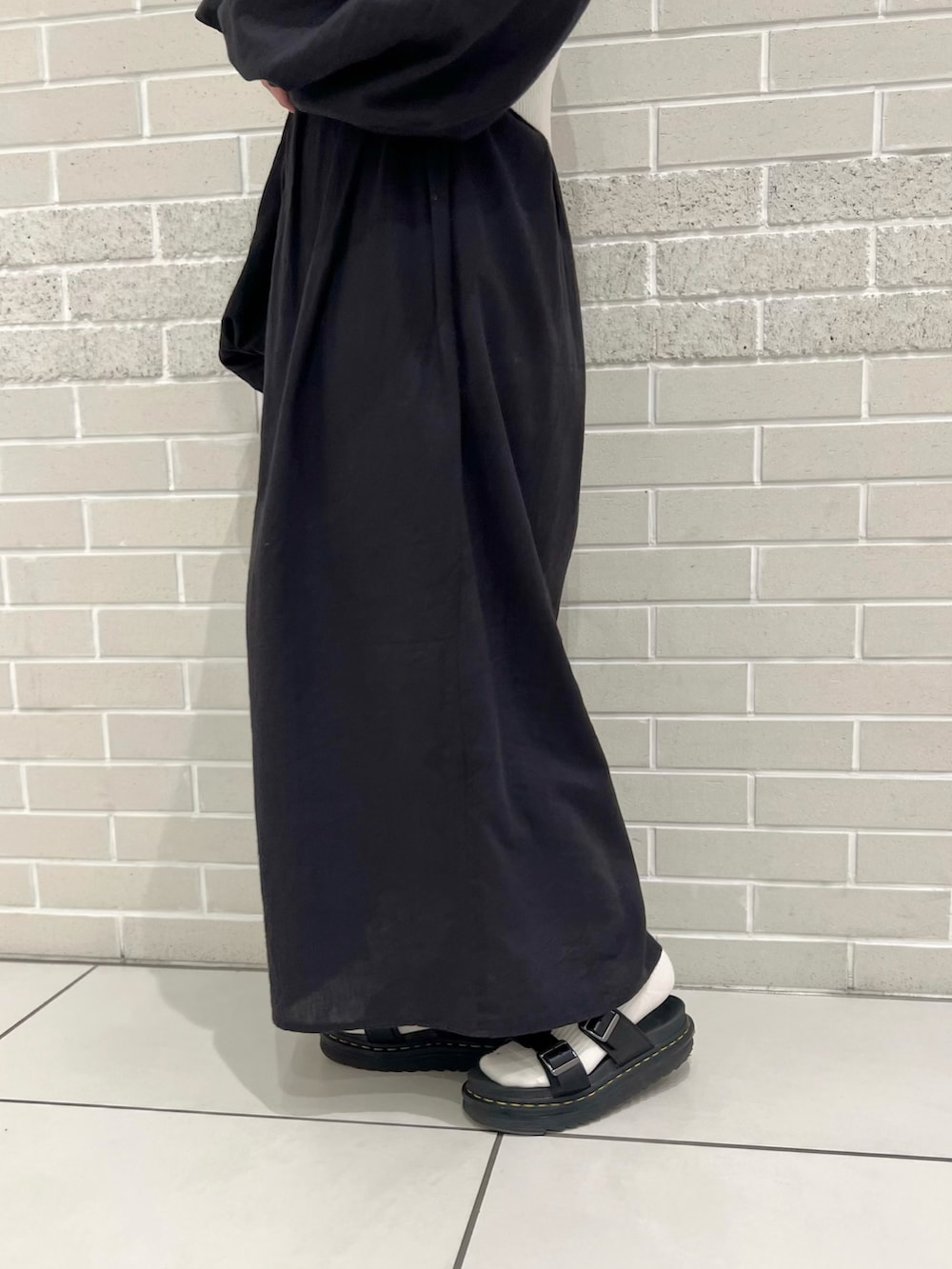 ブラック系のワンピース、ホワイト系のチューブトップ、ベージュ系のワンピースを着用したレディースの春コーディネートの5枚目の写真