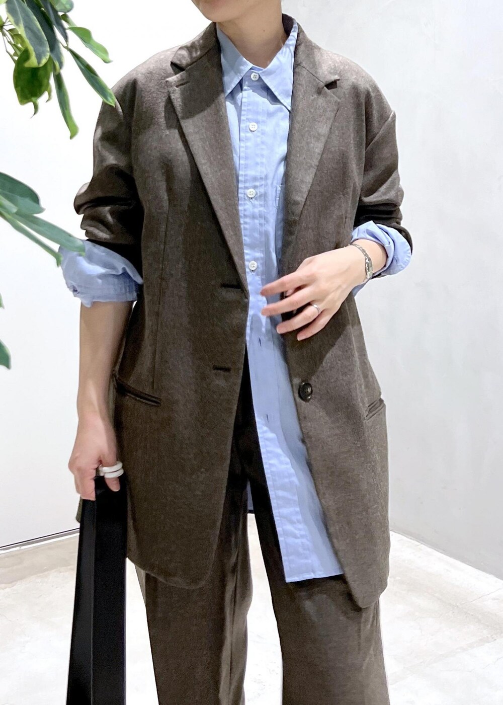 ブルー系のシャツ/ブラウス、ブラック系のショルダーバッグ、ブラウン系のスラックスを着用したレディースの秋コーディネートの6枚目の写真