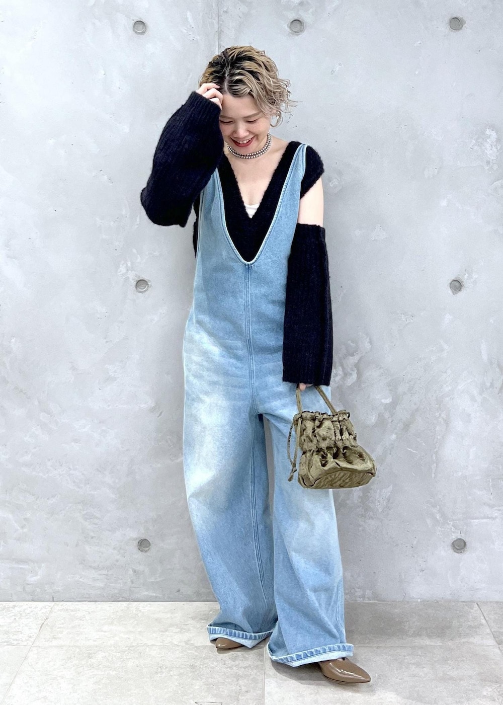 ブラック系のベスト、グリーン系のショルダーバッグ、ブルー系のサロペット/オーバーオールを着用したレディースの夏コーディネートの2枚目の写真