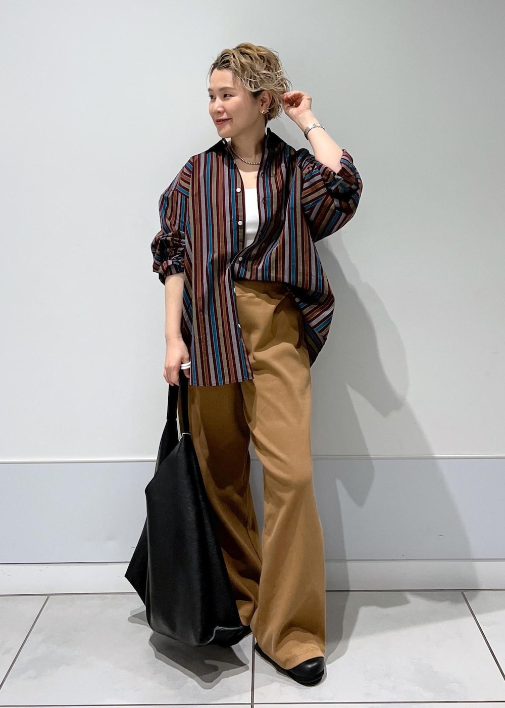 ブラック系のトートバッグ、ブラック系のスニーカー、ブラウン系のその他パンツを着用したレディースの冬コーディネートの4枚目の写真