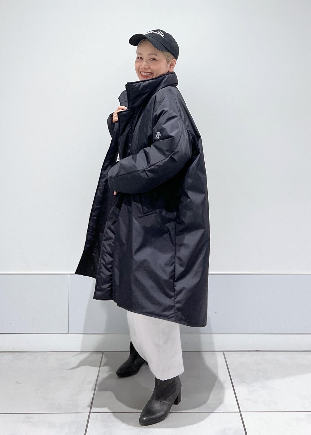 ブラック系のブーツ、ブラック系のTシャツ/カットソー、ブラック系のトートバッグを着用したレディースの冬コーディネートの3枚目の写真