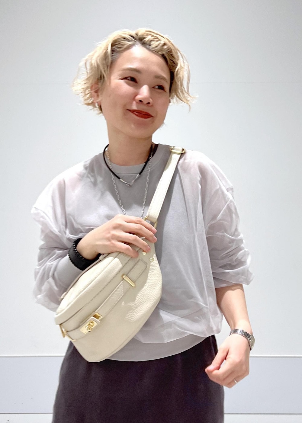 ホワイト系のサンダル、ベージュ系のボディバッグ/ウエストポーチ、グレー系のワンピースを着用したレディースの春コーディネートの6枚目の写真