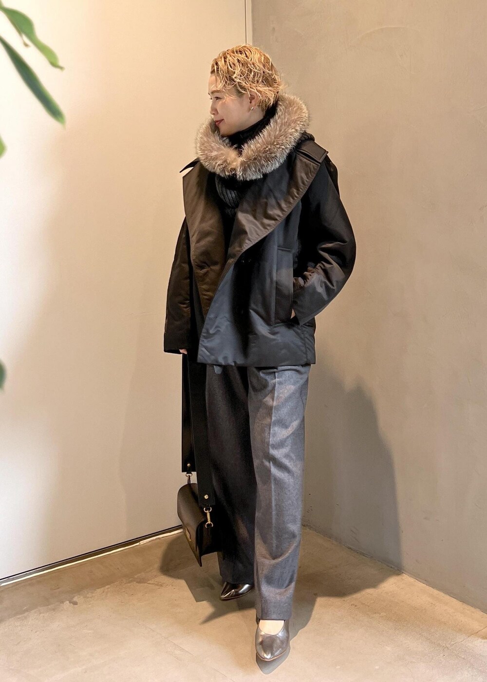 ブラック系のショルダーバッグ、グレー系のニット/セーター、グレー系のスラックスを着用したレディースの秋コーディネートの3枚目の写真