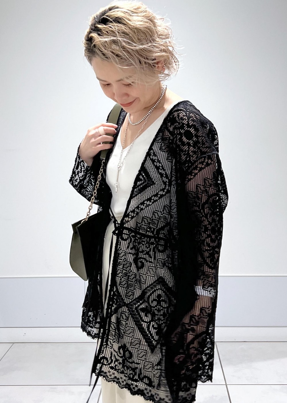 ホワイト系のカーゴパンツ、ホワイト系のキャミソール、ブラック系のノーカラージャケットを着用したレディースの夏コーディネートの5枚目の写真