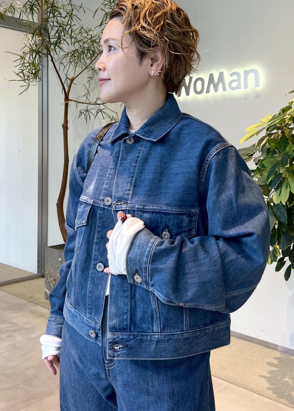 ブラック系のショルダーバッグ、ブルー系のデニムジャケット、ブルー系のデニムパンツを着用したレディースの秋コーディネートの5枚目の写真