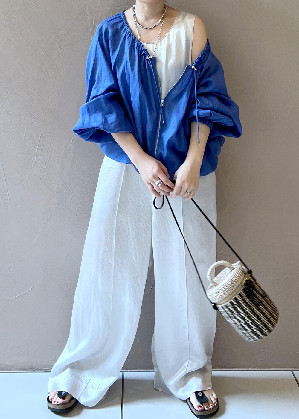 ホワイト系のショルダーバッグ、ブルー系のブルゾン、ホワイト系のつなぎ/オールインワンを着用したレディースの夏コーディネートの5枚目の写真