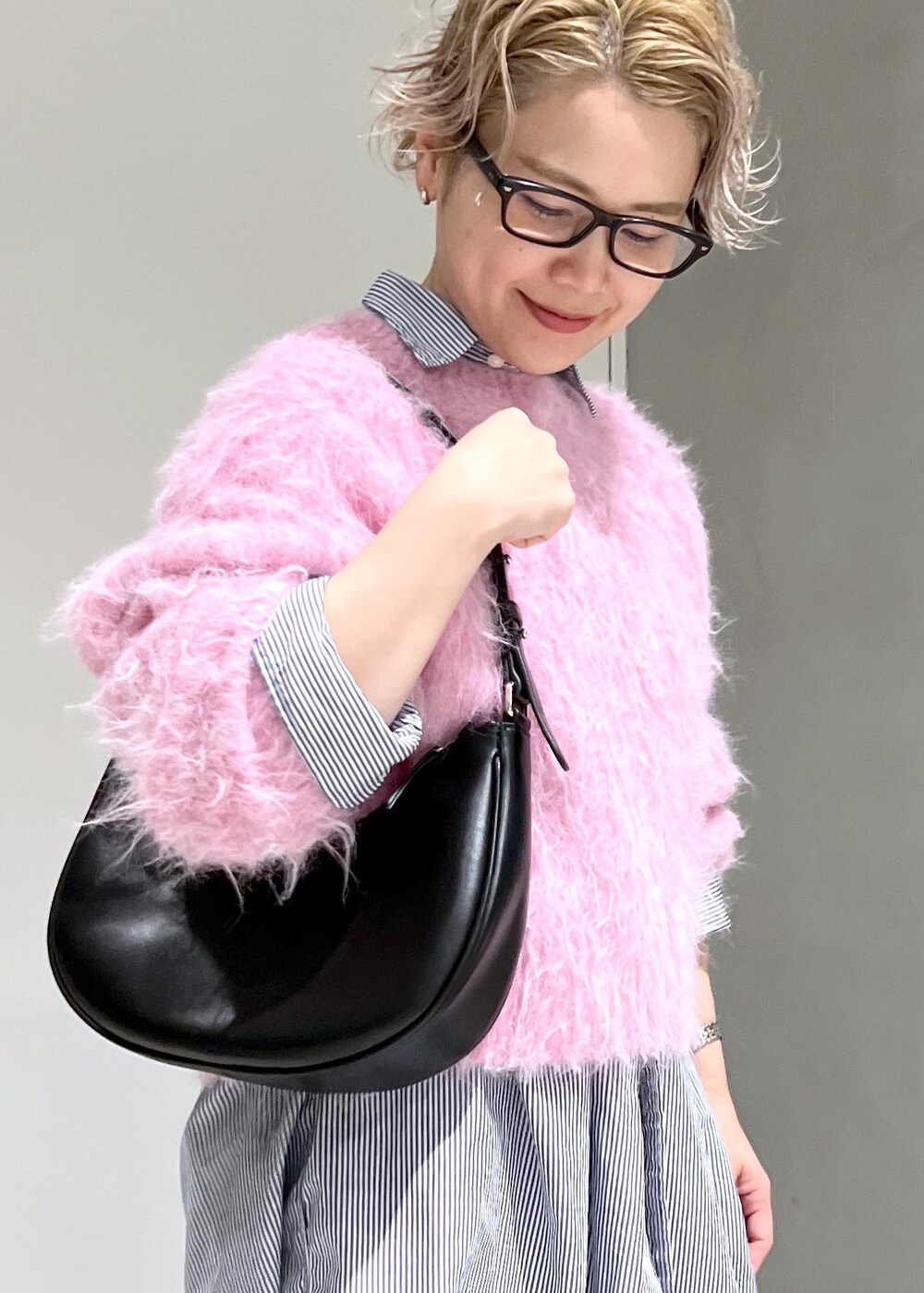 ブラック系のブーツ、ピンク系のニット/セーター、ブラック系のデニムパンツを着用したレディースの秋コーディネートの8枚目の写真