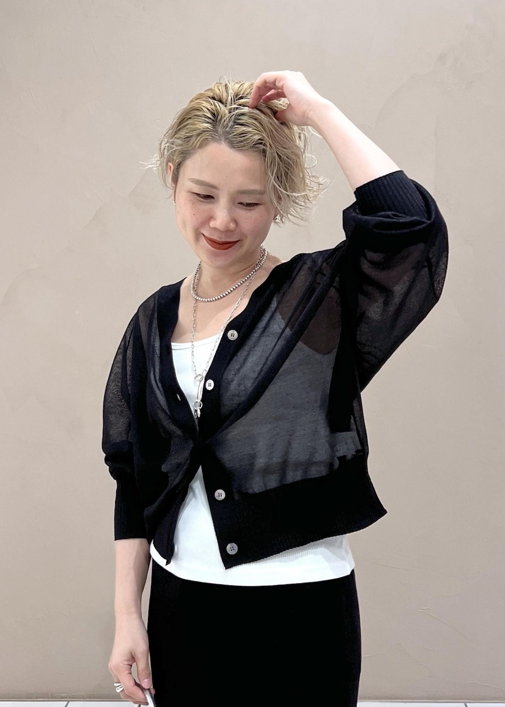 ホワイト系のタンクトップ、ブラック系のカーディガン/ボレロ、ブルー系のデニムパンツを着用したレディースの夏コーディネートの7枚目の写真