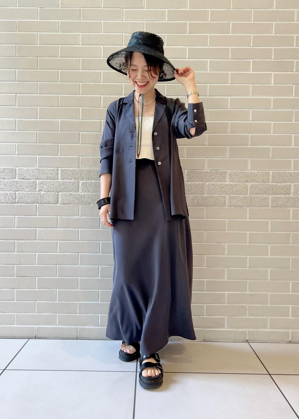 グレー系のスカート、グレー系のシャツ/ブラウス、ホワイト系のチューブトップを着用したレディースの春コーディネートの3枚目の写真