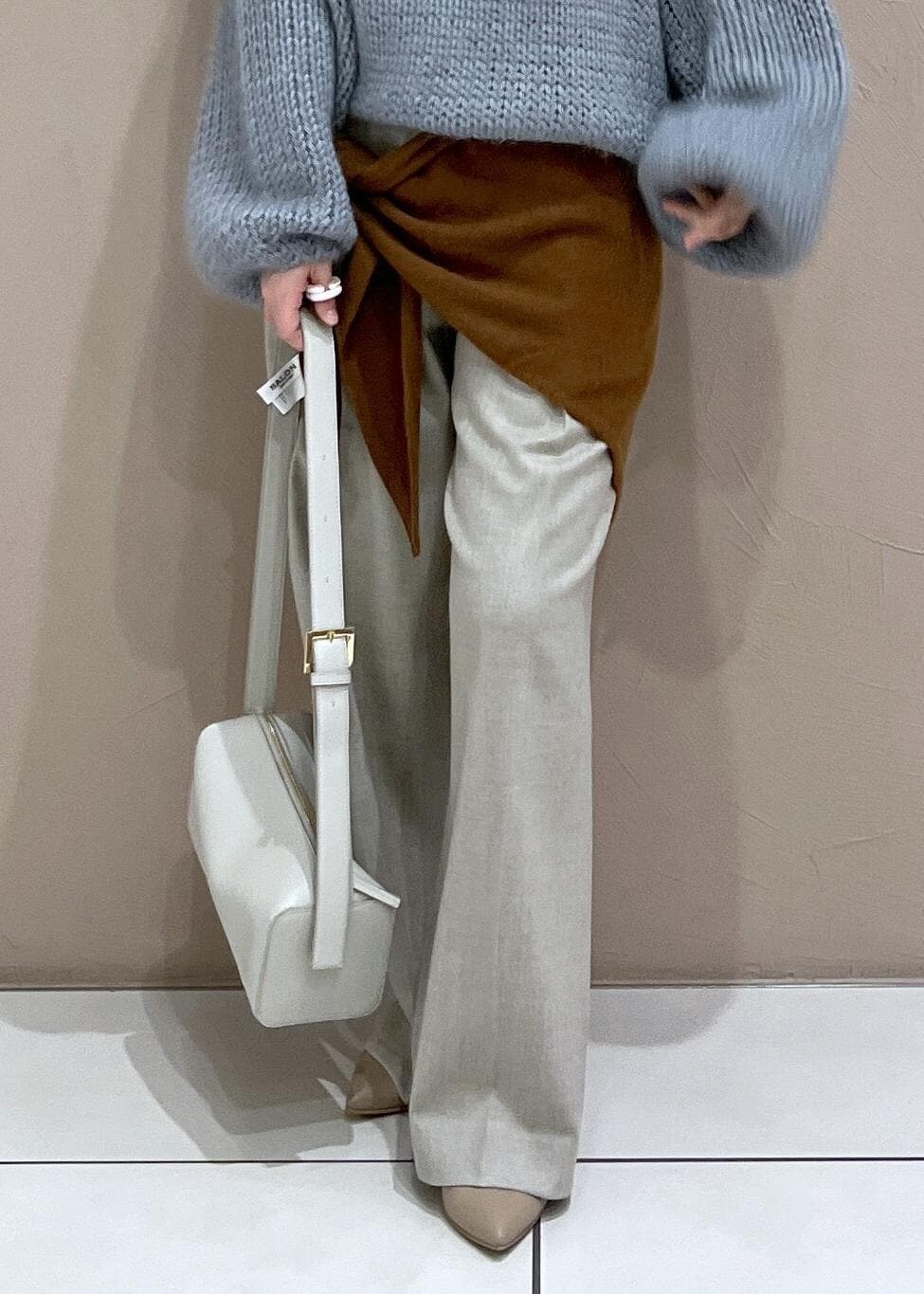 グレー系のショルダーバッグ、ベージュ系のスラックス、ブルー系のニット/セーターを着用したレディースの秋コーディネートの8枚目の写真