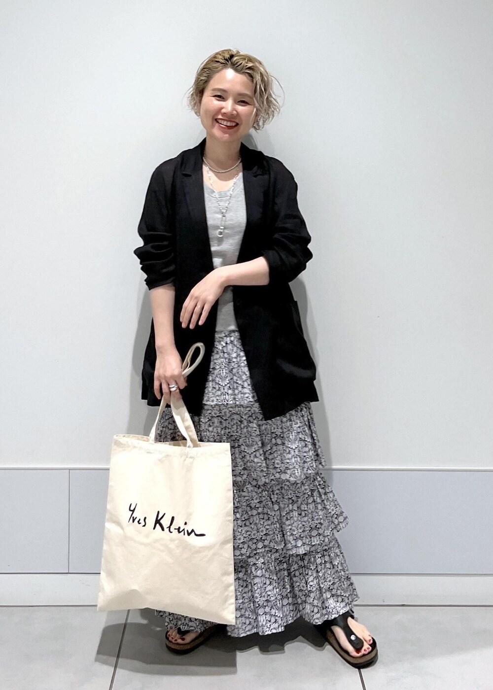 ブラック系のテーラードジャケット、ブラック系のスカートを着用したレディースの夏コーディネートの3枚目の写真