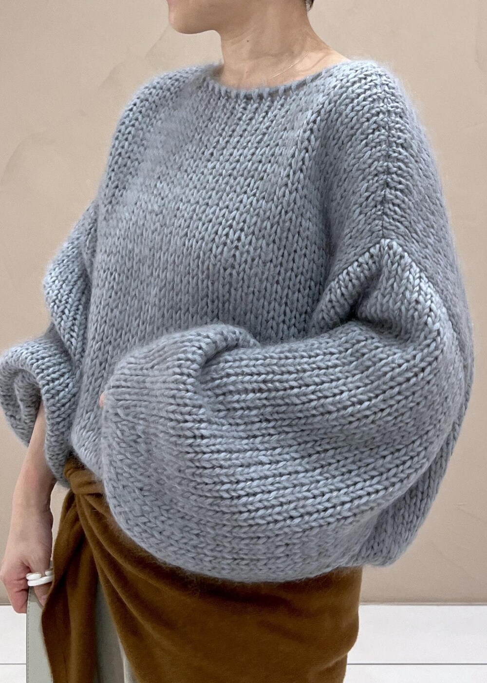 グレー系のショルダーバッグ、ベージュ系のスラックス、ブルー系のニット/セーターを着用したレディースの秋コーディネートの7枚目の写真