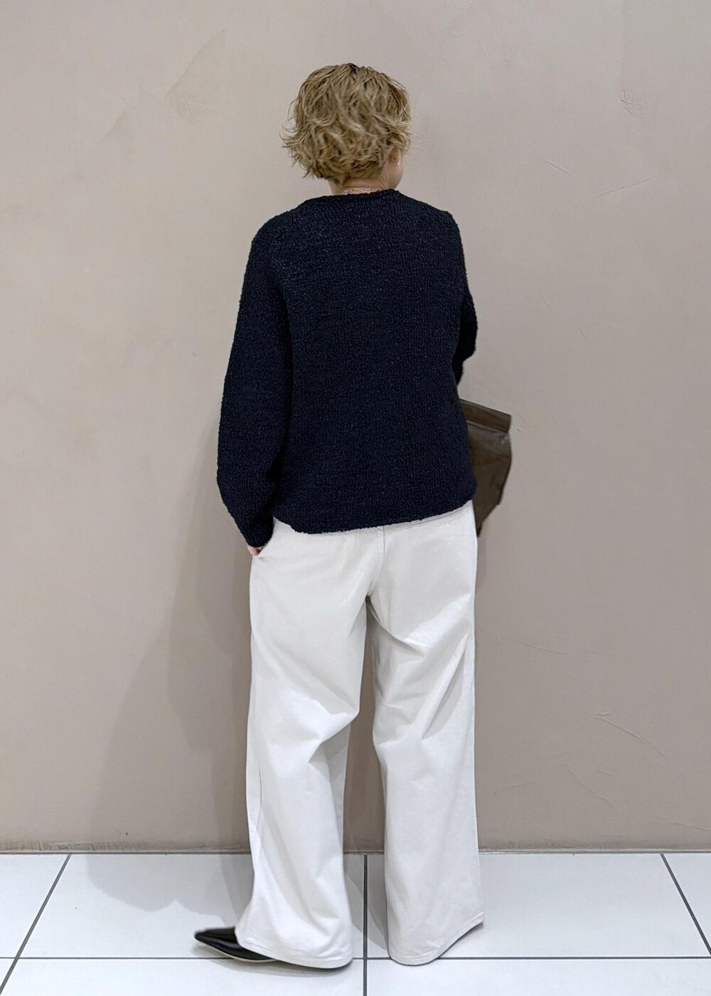 ブラック系のカーディガン/ボレロ、ホワイト系のサロペット/オーバーオール、ブラック系のローファーを着用したレディースの冬コーディネートの4枚目の写真